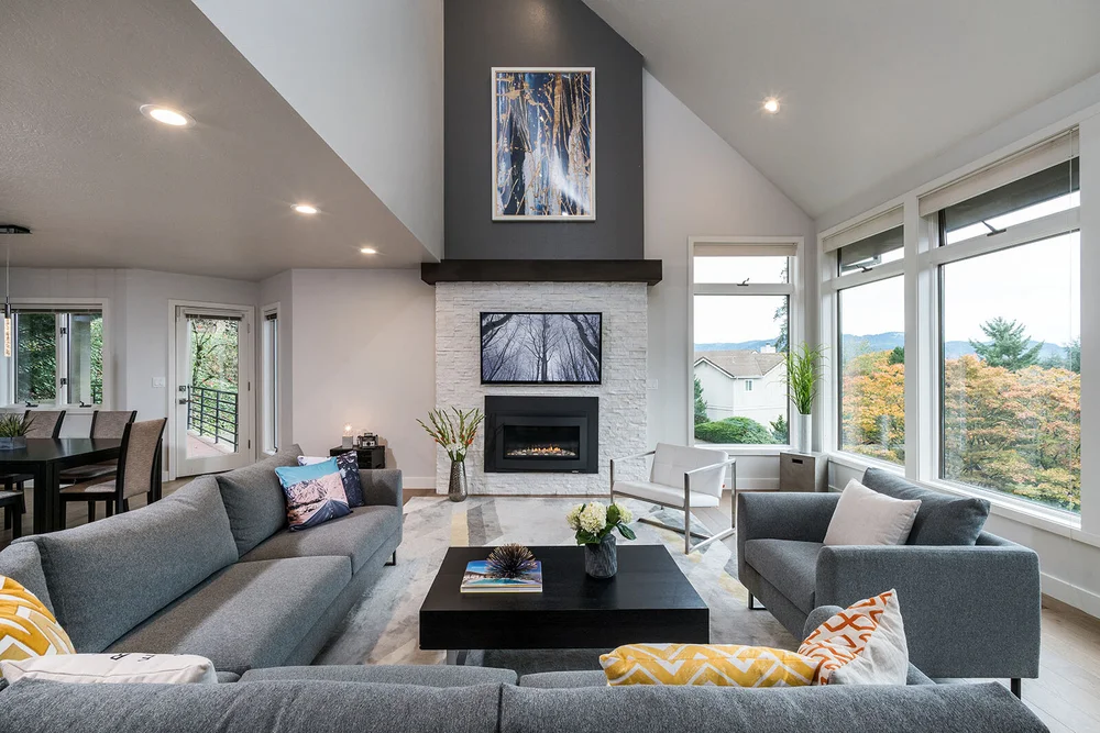 Living room with a gray sectional facing a stone fireplace