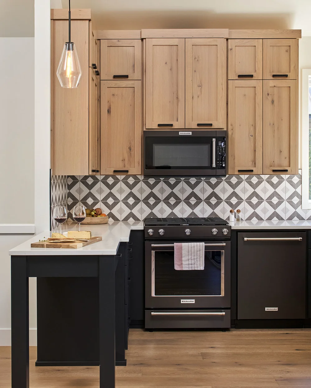 Kitchen with a patterned tile backsplash and natural wood cabinets