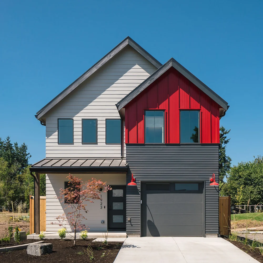 Narrow two-storey home with a red gable and gray siding