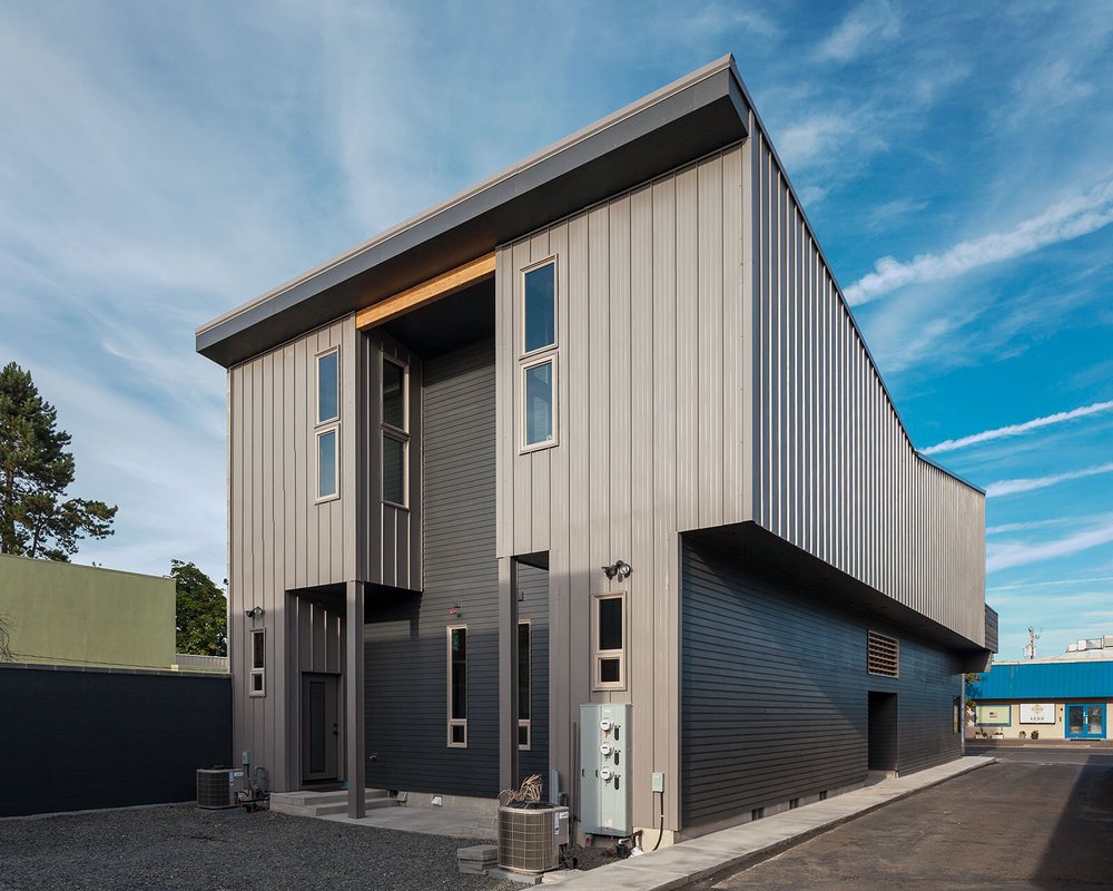 Tall modern home with a sloped roof and vertical siding
