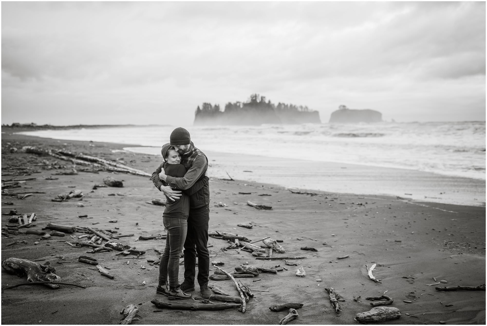  A couple embracing on a rainy winter day on Rialto Beach. 