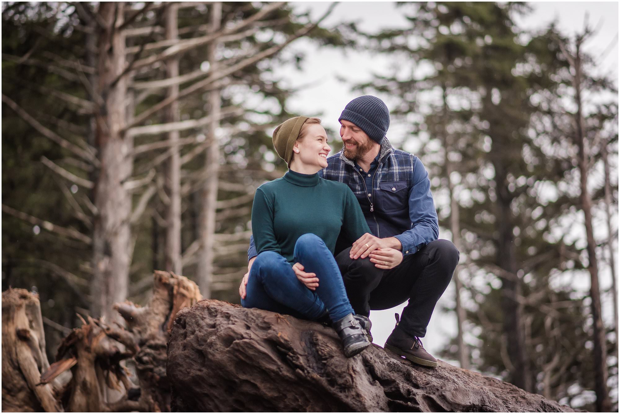  A couple cuddles up during their portrait session on a stormy beach.  