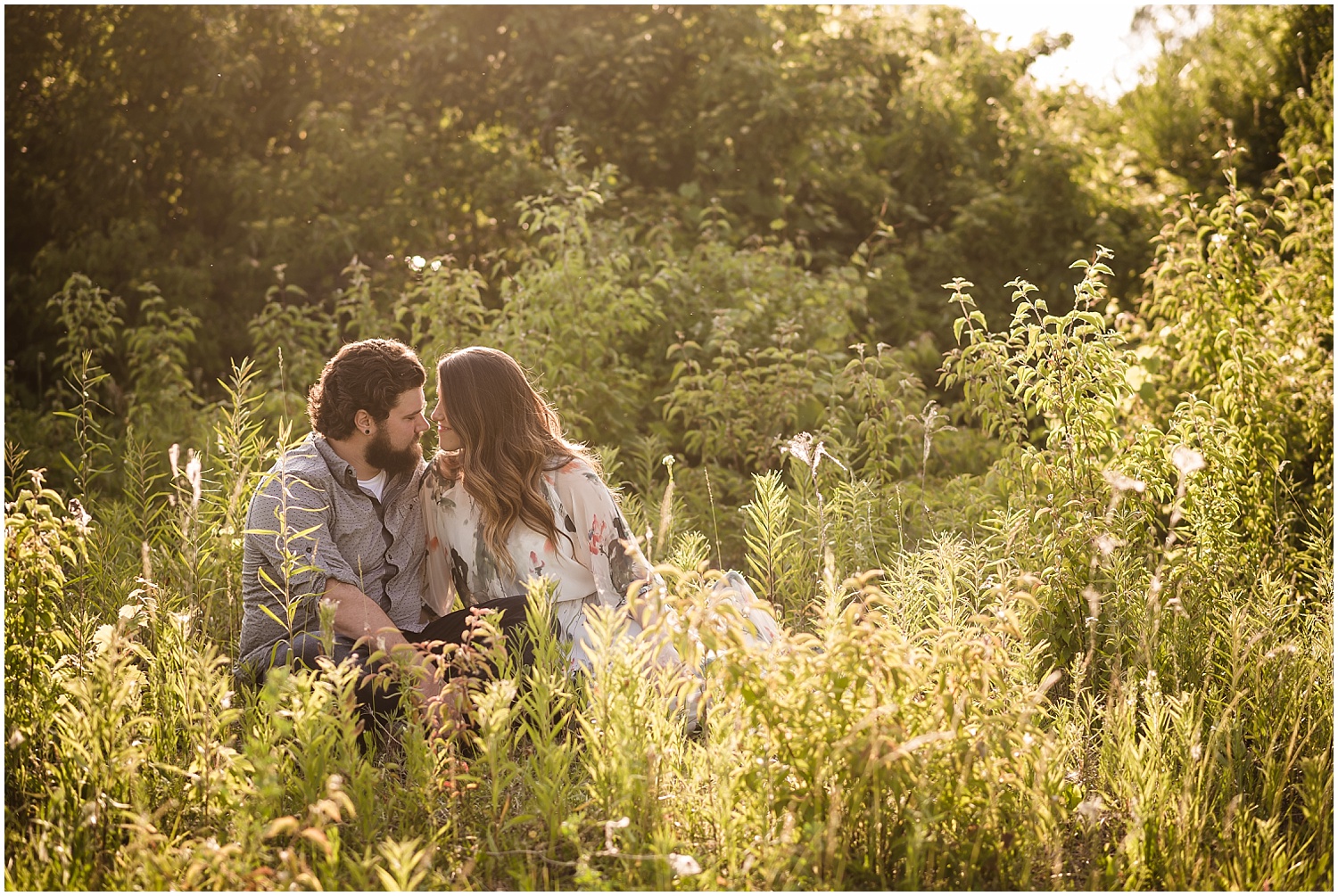  A brunette couple talking quietly in a field next to Lake Erie in Michigan.  