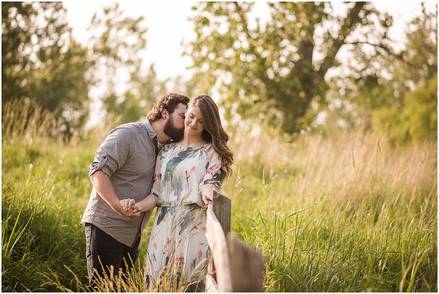  A man kisses his girlfriend’s neck during their engagement session at a state park.  