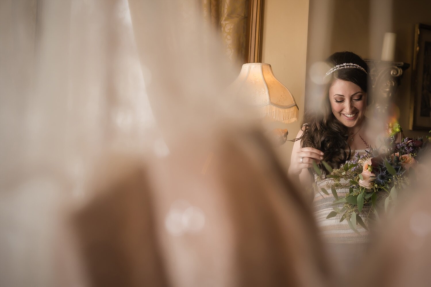  A reflection of a bride in a mirror while she’s getting ready for her wedding ceremony.  