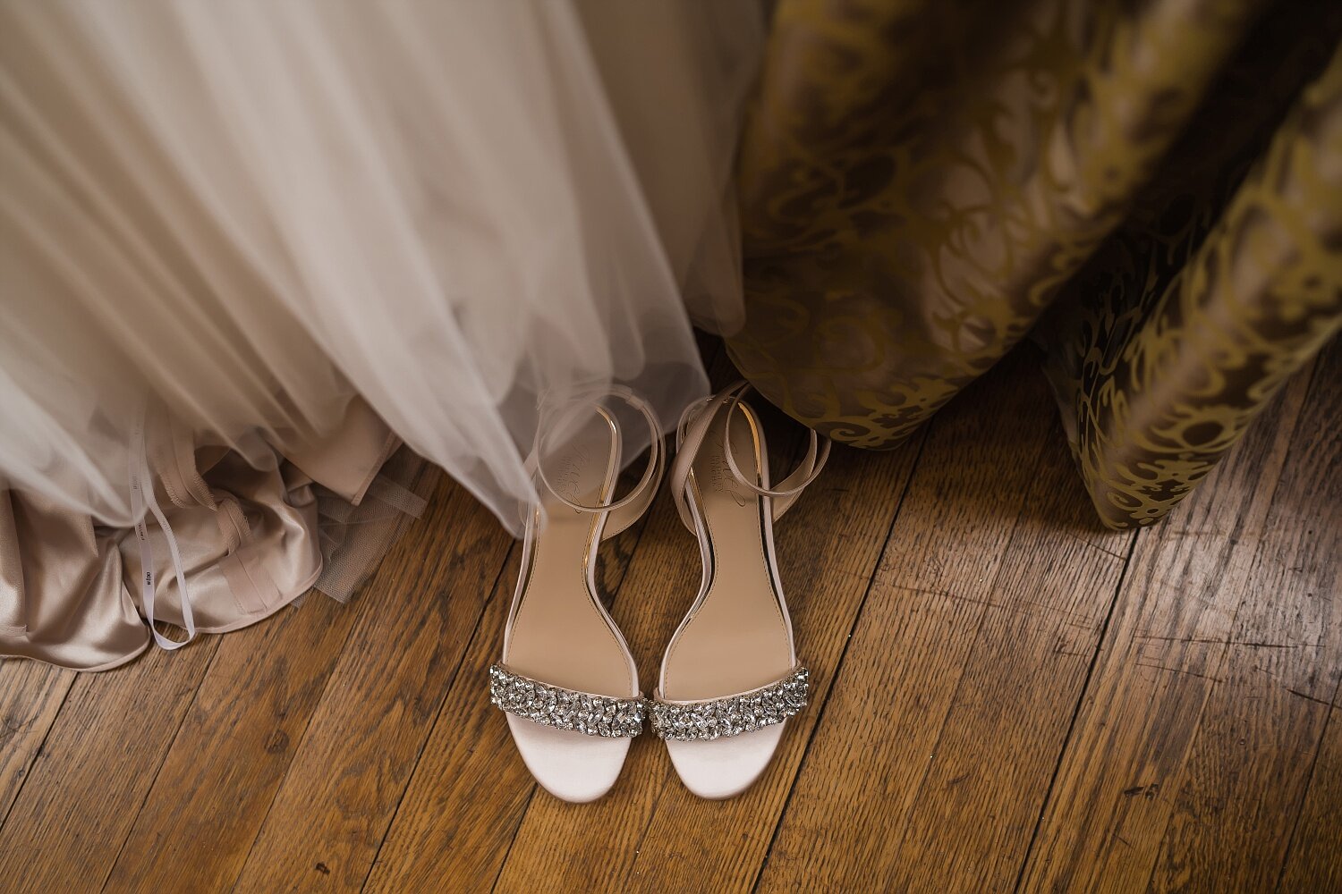  Sparkly wedding sandals sitting on a wood floor.  