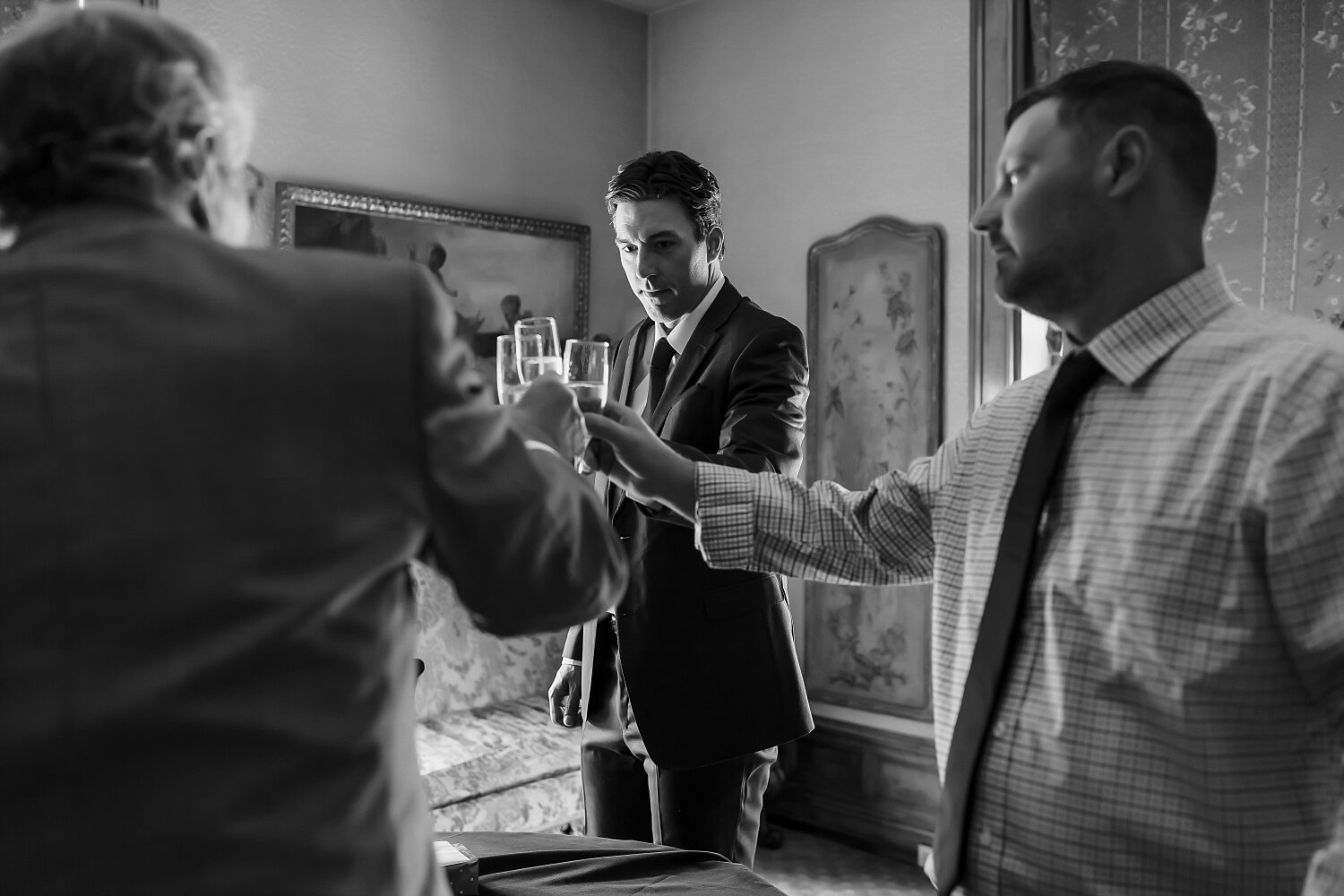  A groom, his best man, and dad all share a toast before their outdoor wedding ceremony.  