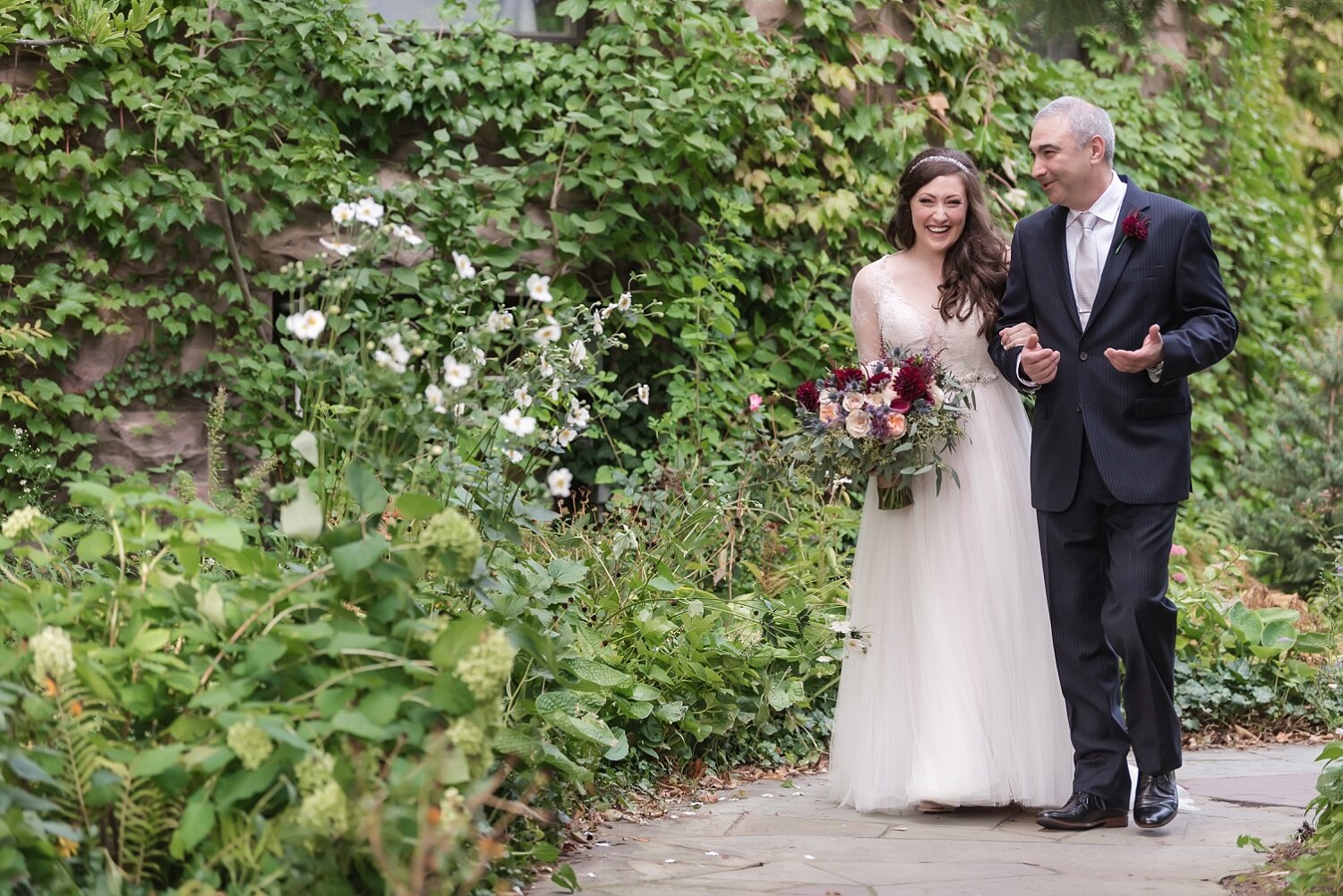  A bride nervously laughs while being escorted down the aisle.  