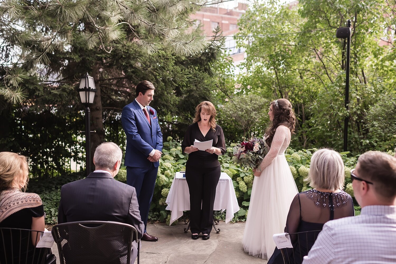  A couple listening to their wedding officiant during their outdoor wedding ceremony.  