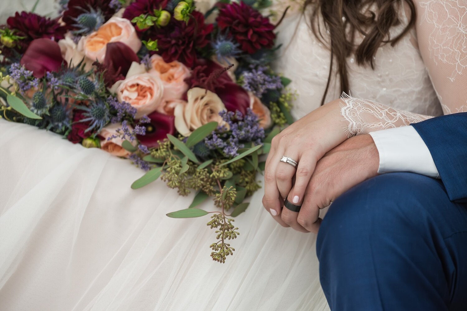  A close-up of hands during a summer outdoor ceremony at a historic venue.  