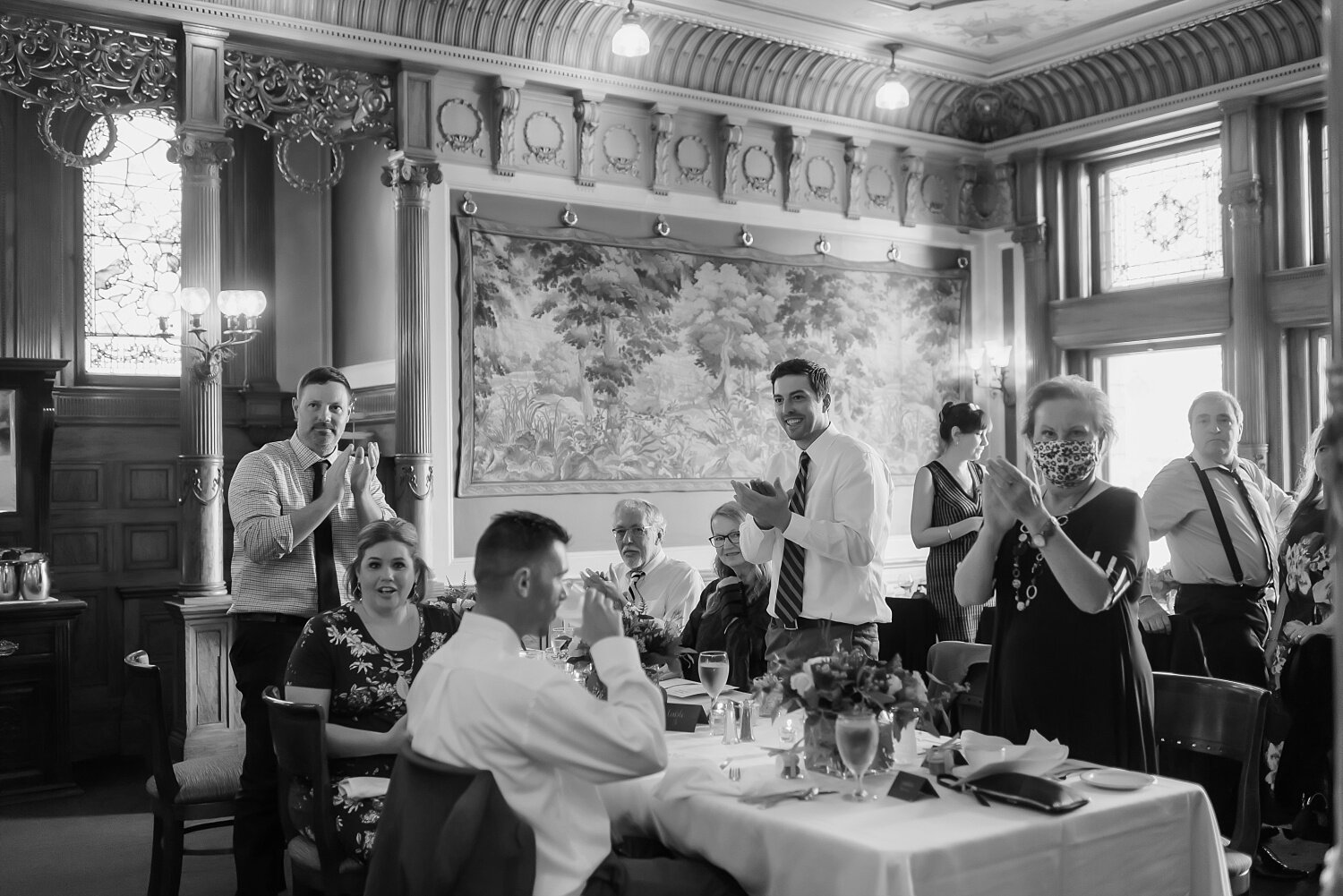  Wedding guests applause the wedding couple as they walk into the reception.  