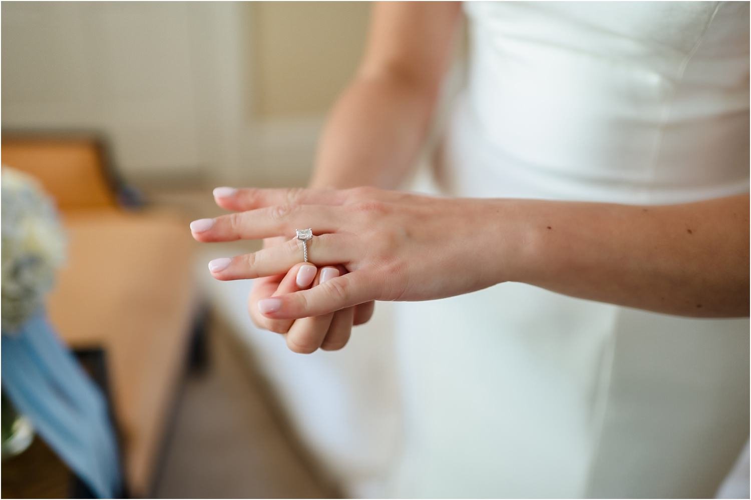  A close-up of a woman putting on her wedding ring.  