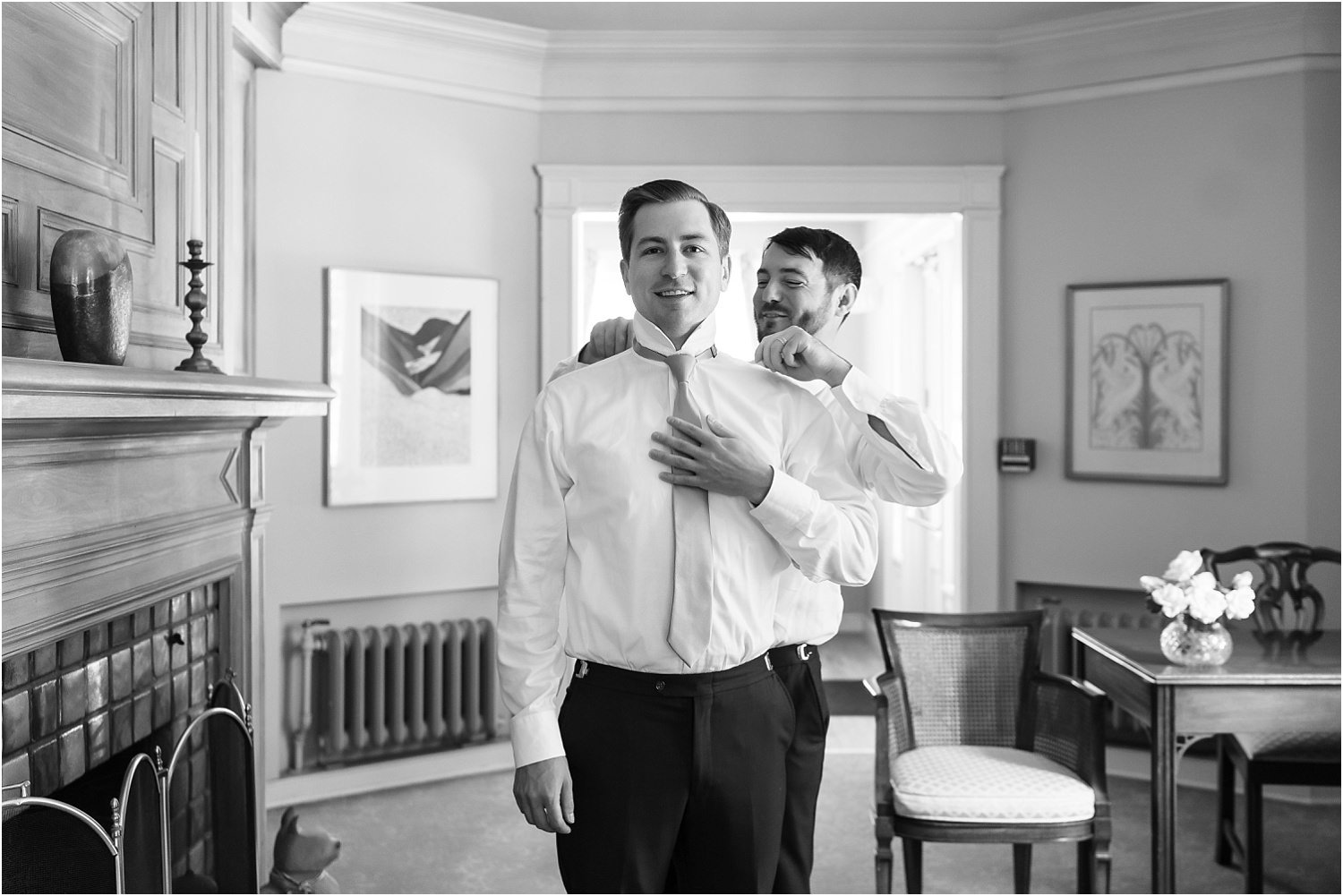  A best man helps his cousin, the groom, get dressed before his ceremony.  