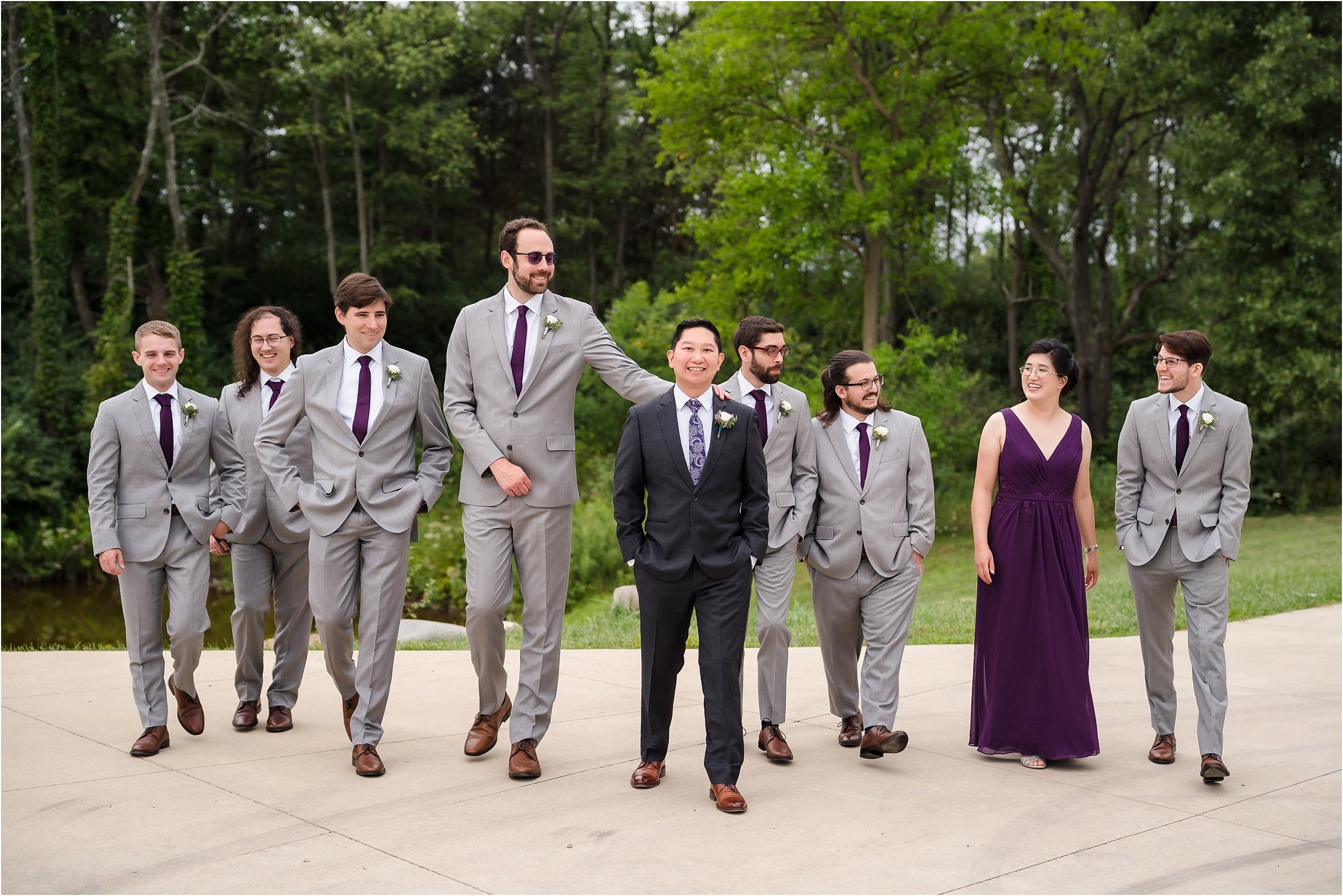  A groom and his groomsmen walking towards the camera and talking.  