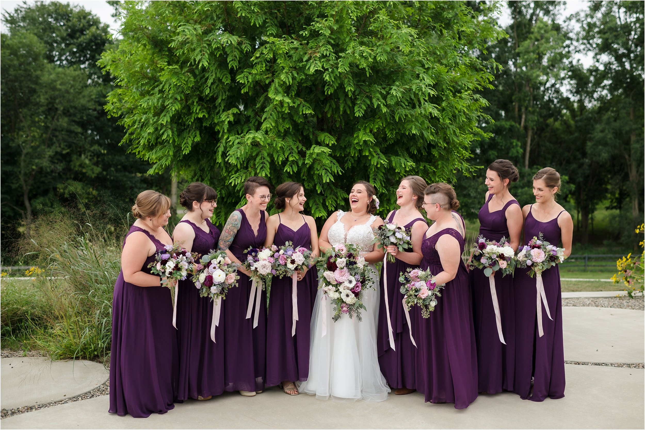  Bridesmaids wearing dark purple talking about a funny story involving the bride.  