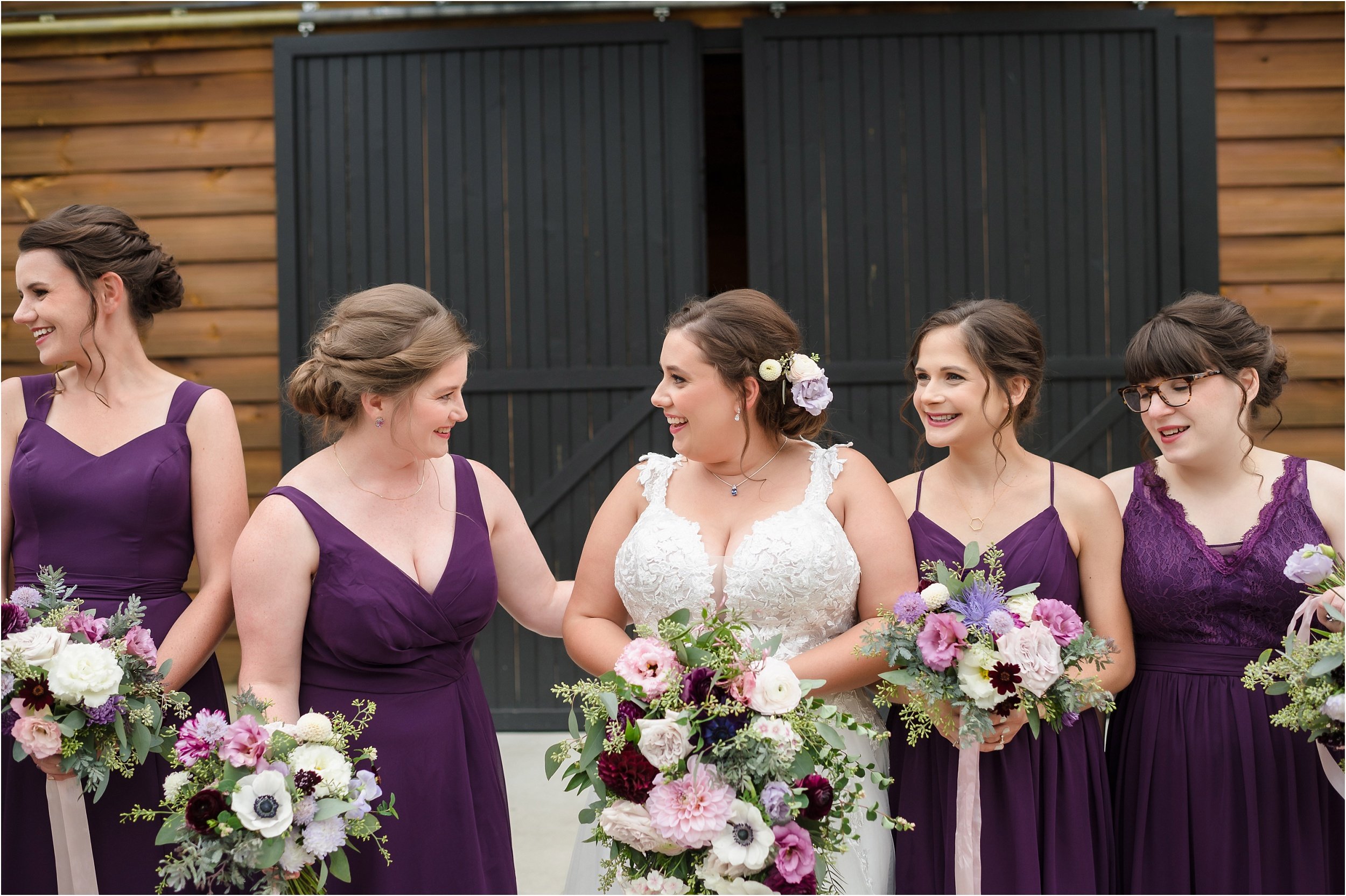  A woman and her bridesmaid talk during wedding day portraits.  