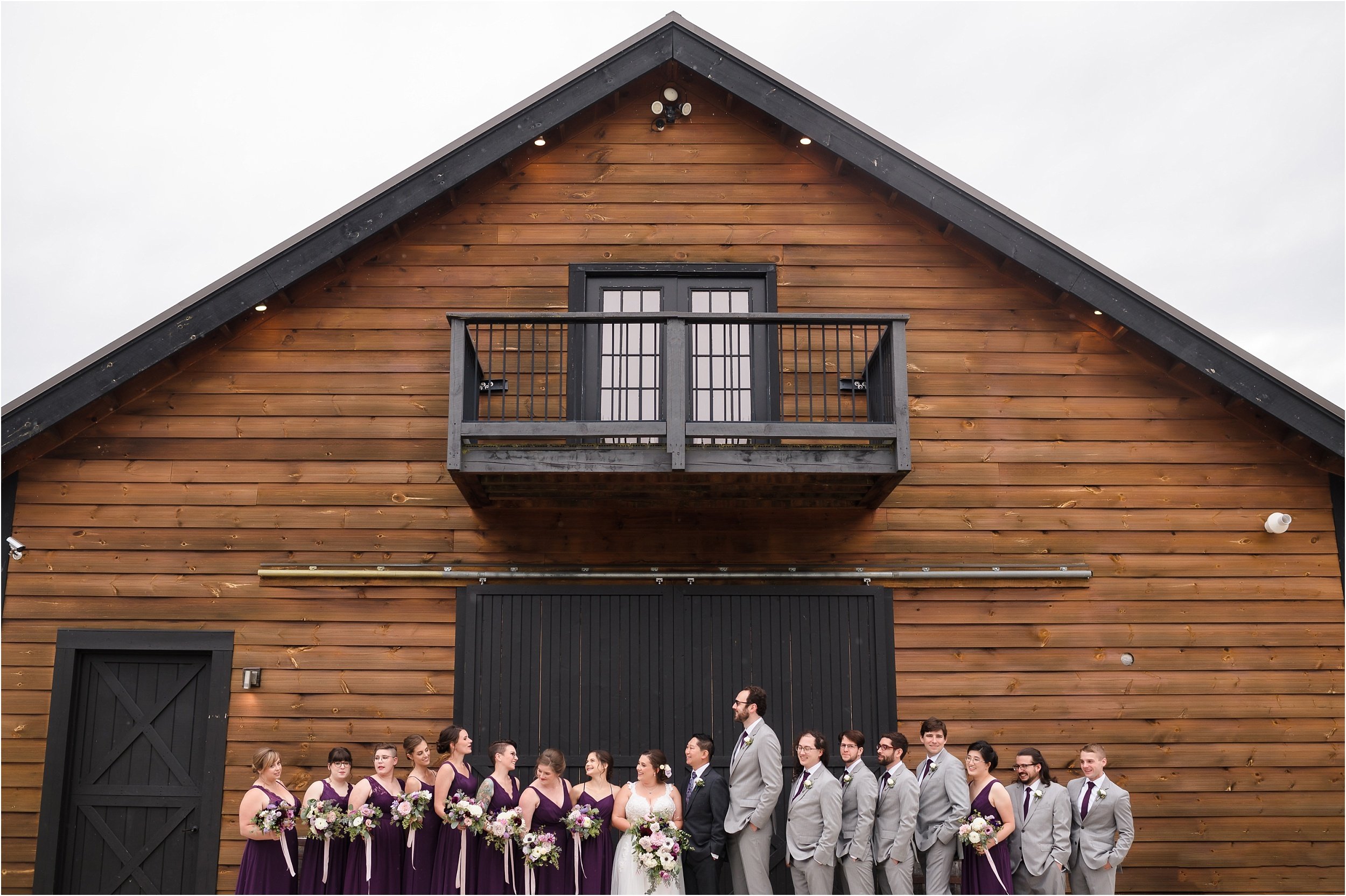  A large wedding party in front of The Pasture Barn at Robin Hills on a rainy day in Chelsea.  