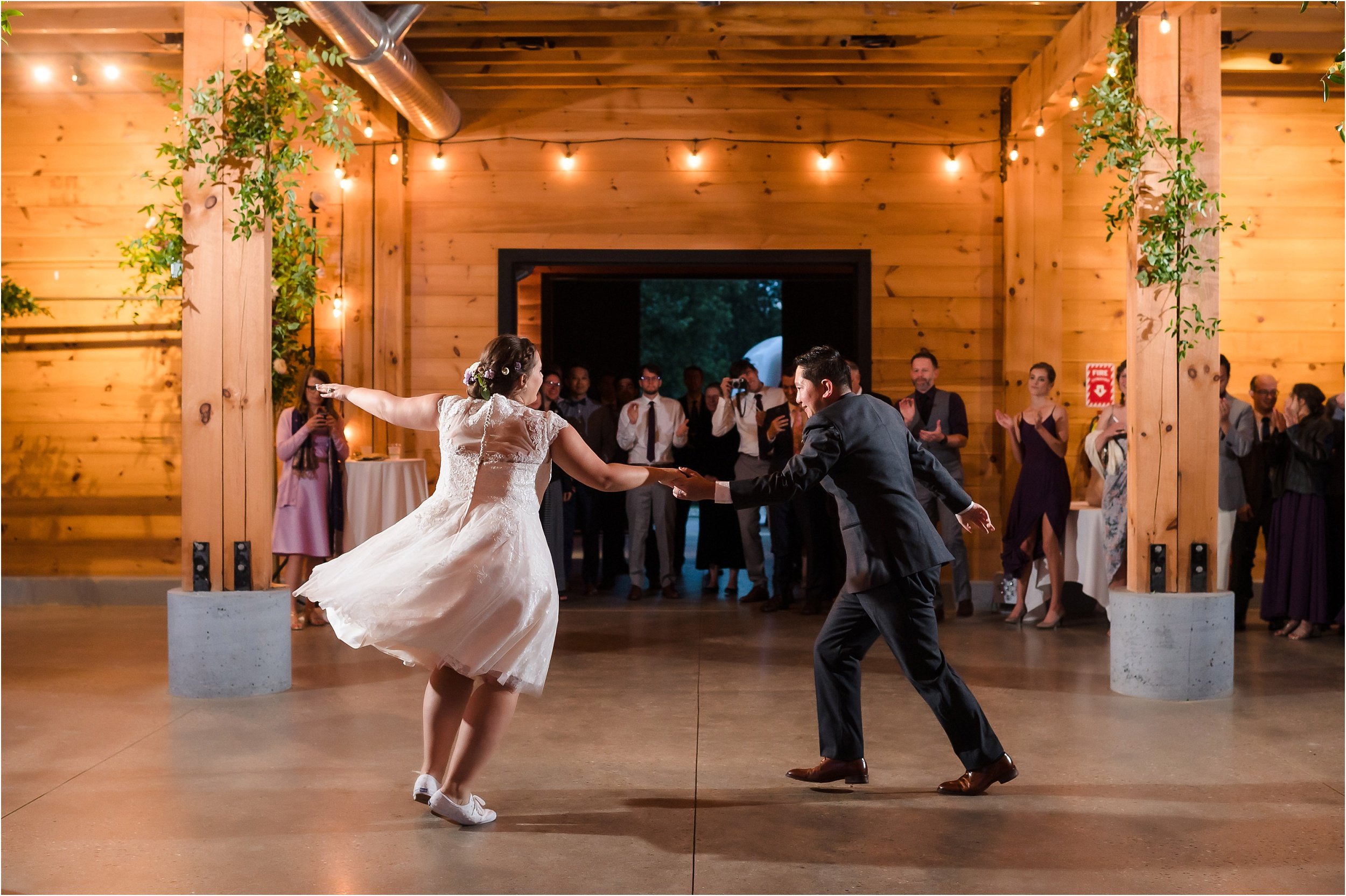  A couple shares a energetic first dance inside a barn.  