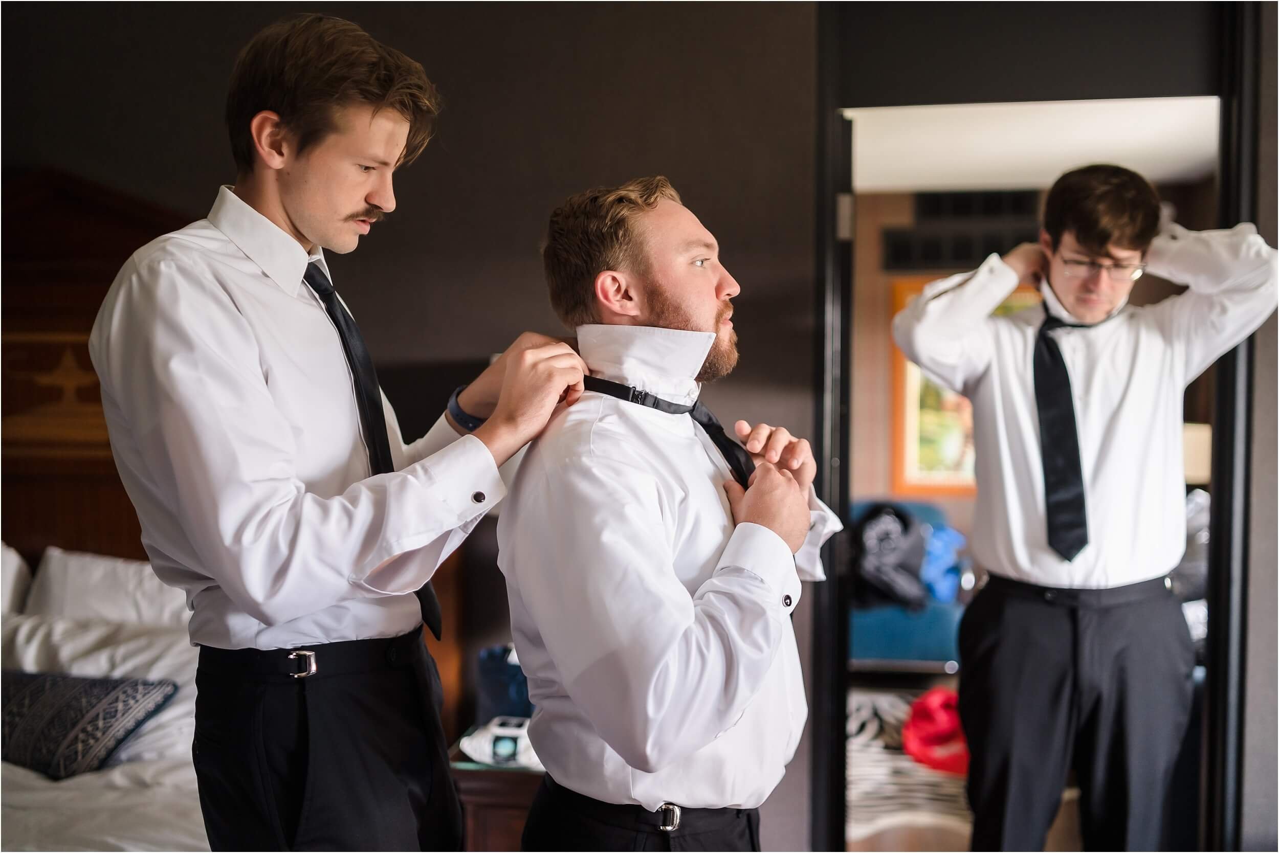  A group of groomsmen wearing black tuxes gets ready at the Graduate Hotel in Ann Arbor.  