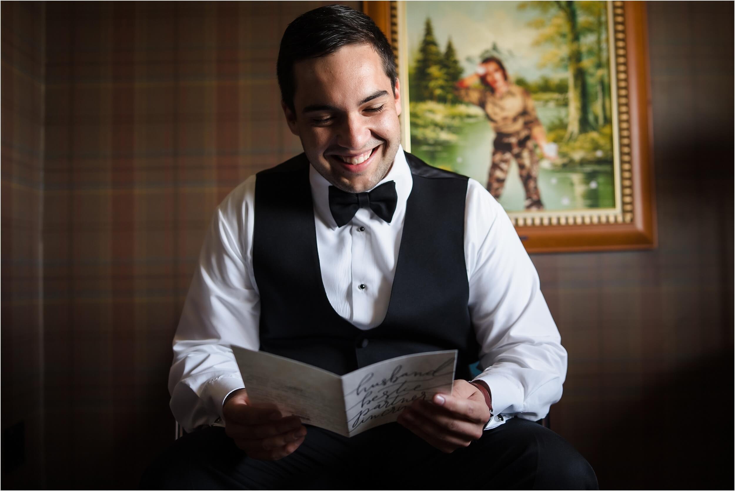  A groom opens up a note from his bride on the morning of his wedding in a downtown Ann Arbor wedding.  