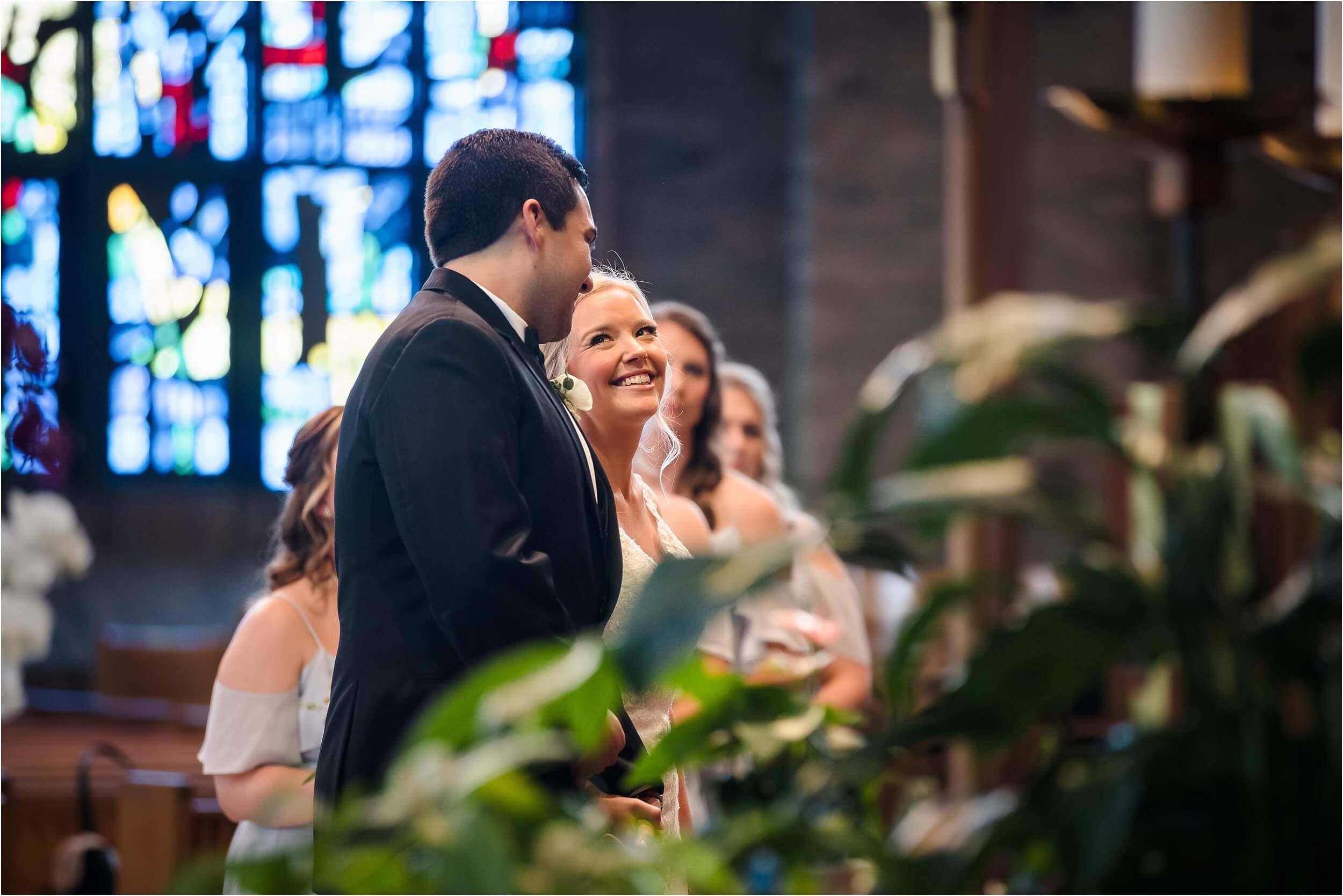  A bride lovingly looks at her soon-to-be husband during their wedding ceremony.  