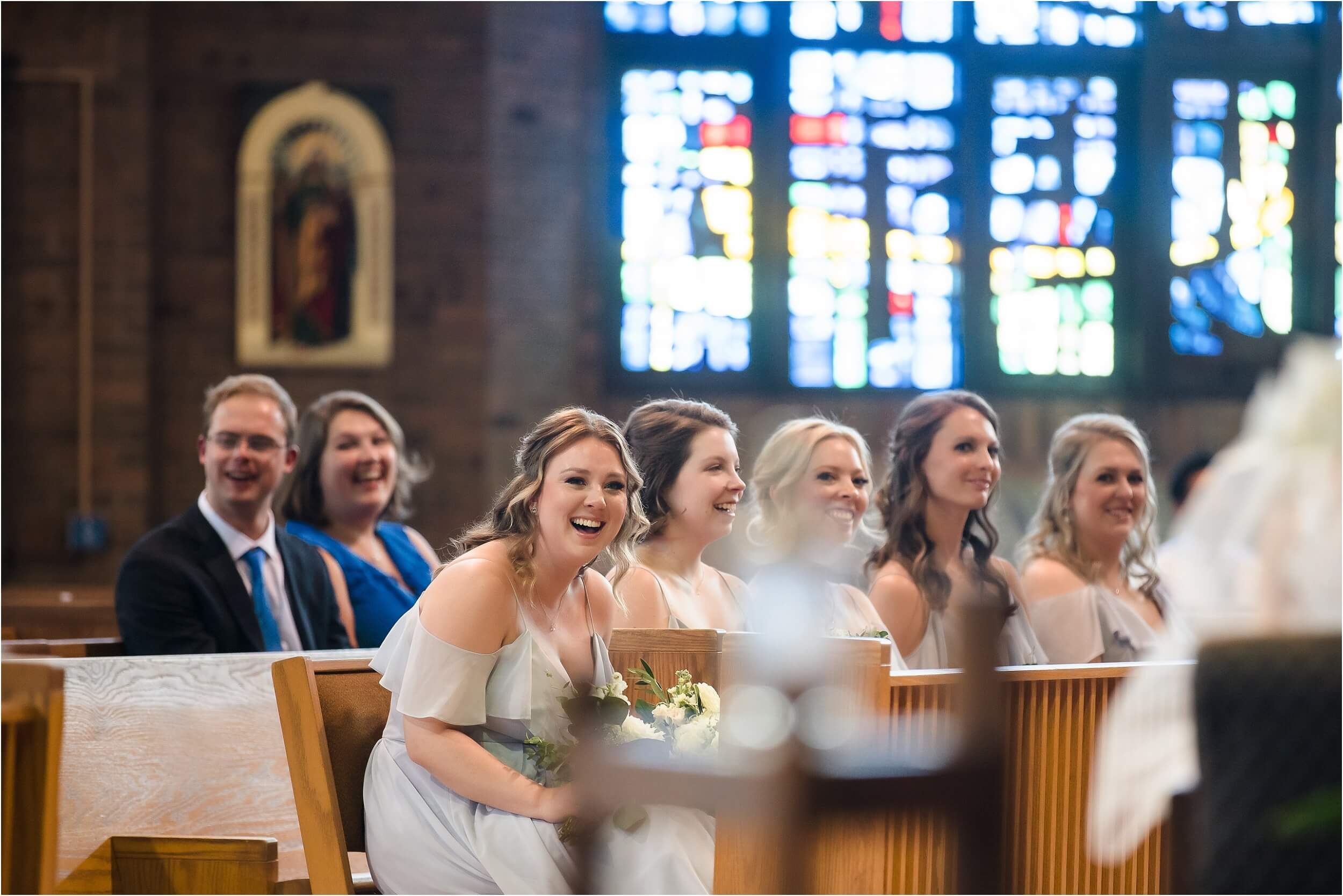  Bridesmaids laugh at a joke during the homily.  