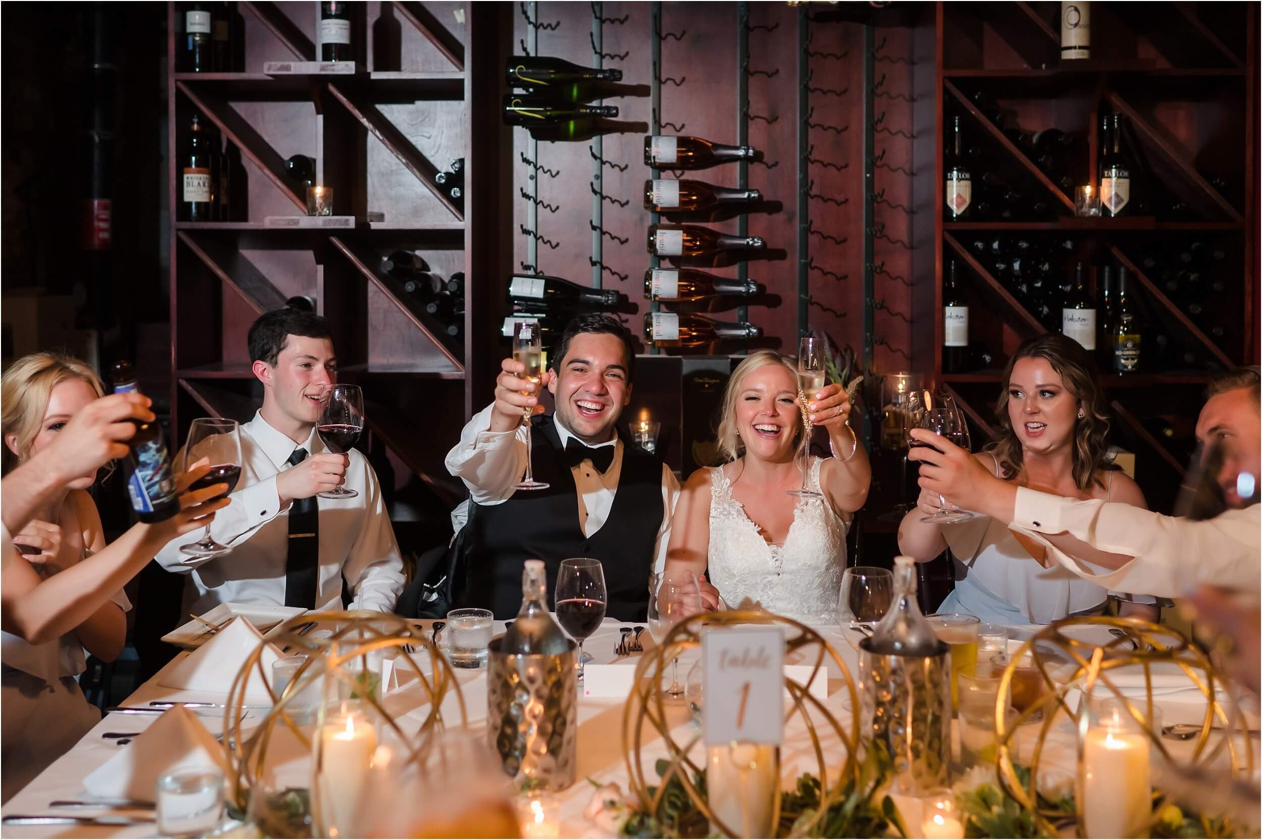  A couple and their wedding party toast before having a farm-to-table dinner at Vinology, a local favorite wine bar in downtown Ann Arbor.  