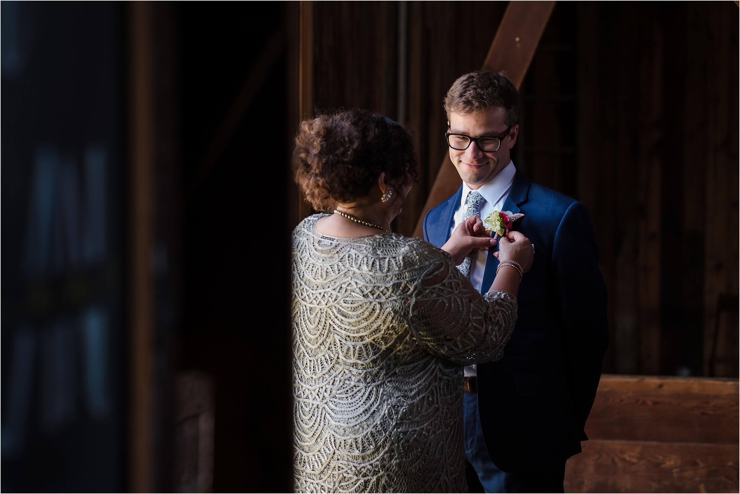  A groom’s mother helps her son get dressed before his wedding.  