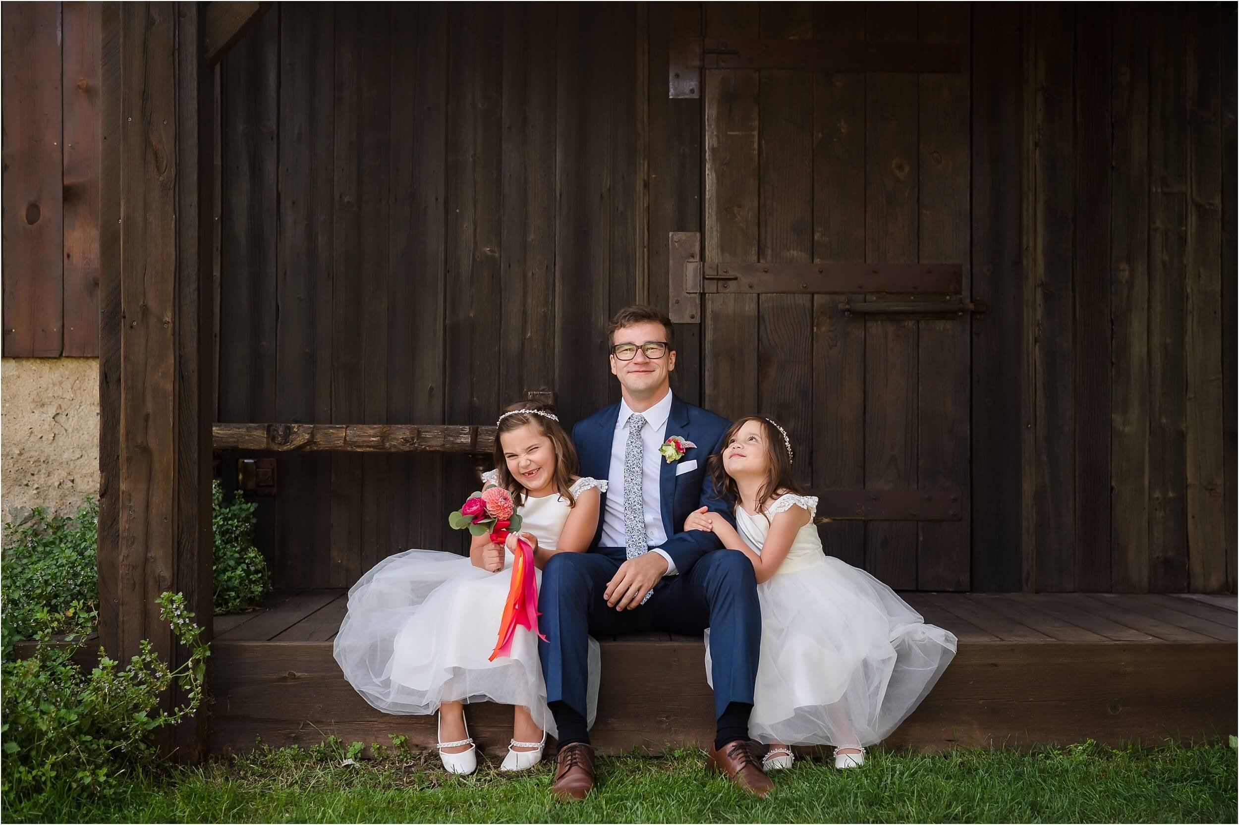  Two flower girls, who are nieces of the groom, hang out with the groom in between portraits.  