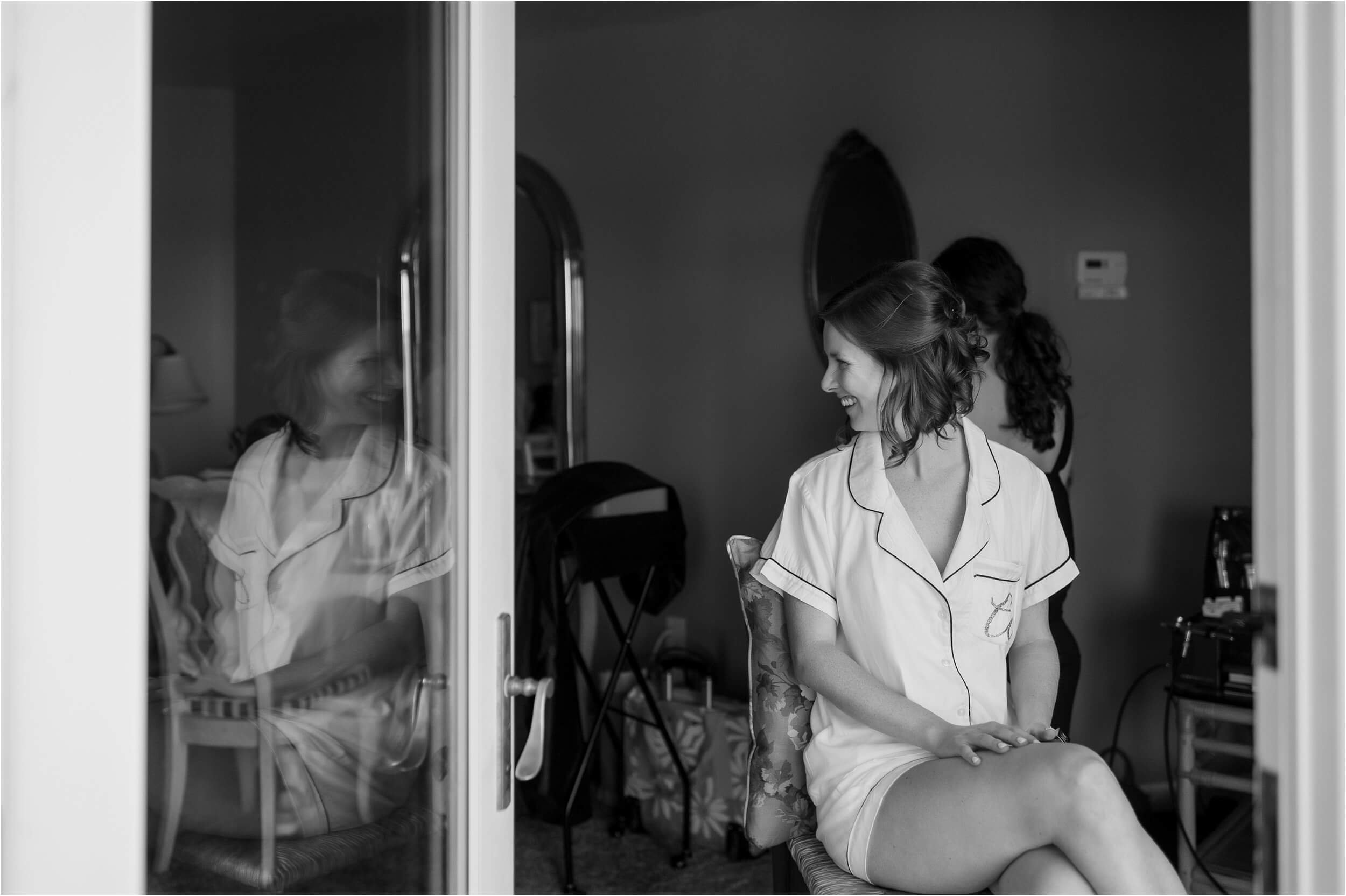  A bride wearing white PJs gets her hair and make-up done before her big day.  