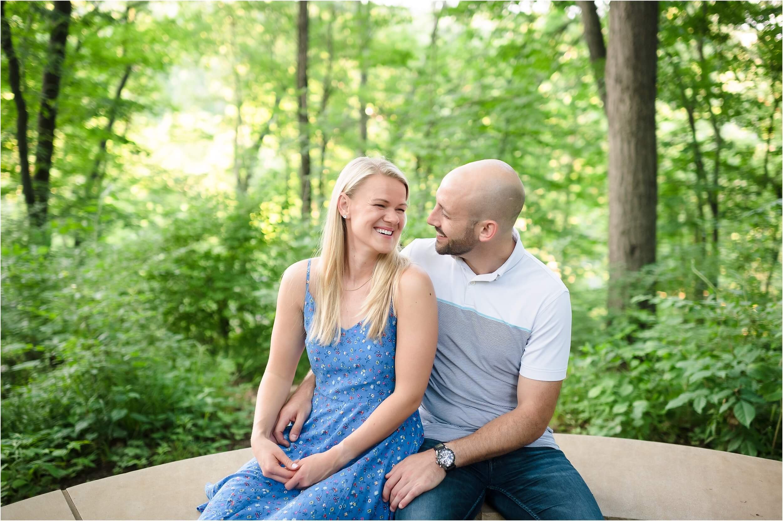  A couple sits together during their Arb engagement session off of a trail.  