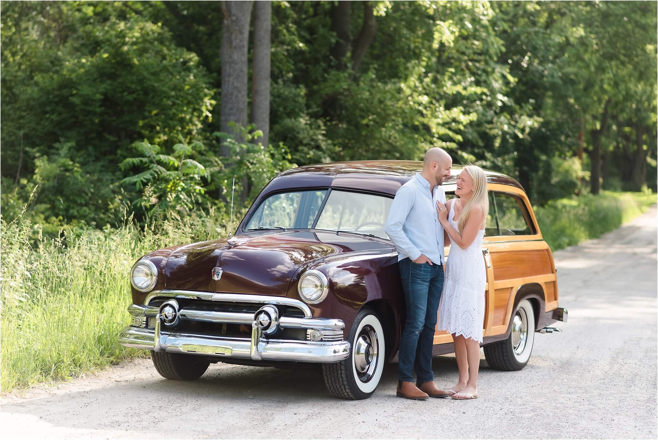  A couple poses in front of a vintage wood paneled car.  