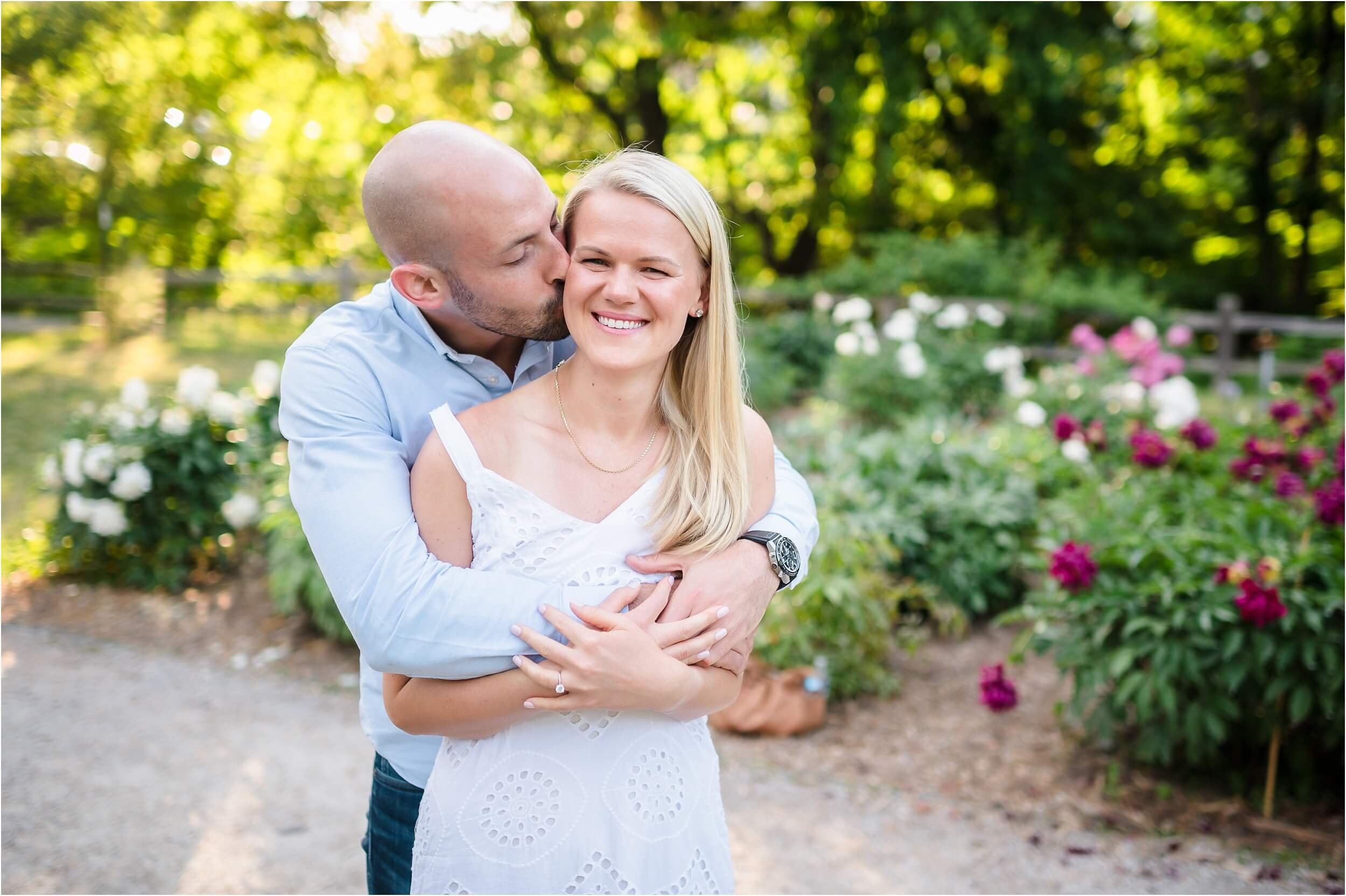  A man embraces his fiance during their sunset engagement session at The Arb Peony Garden.  