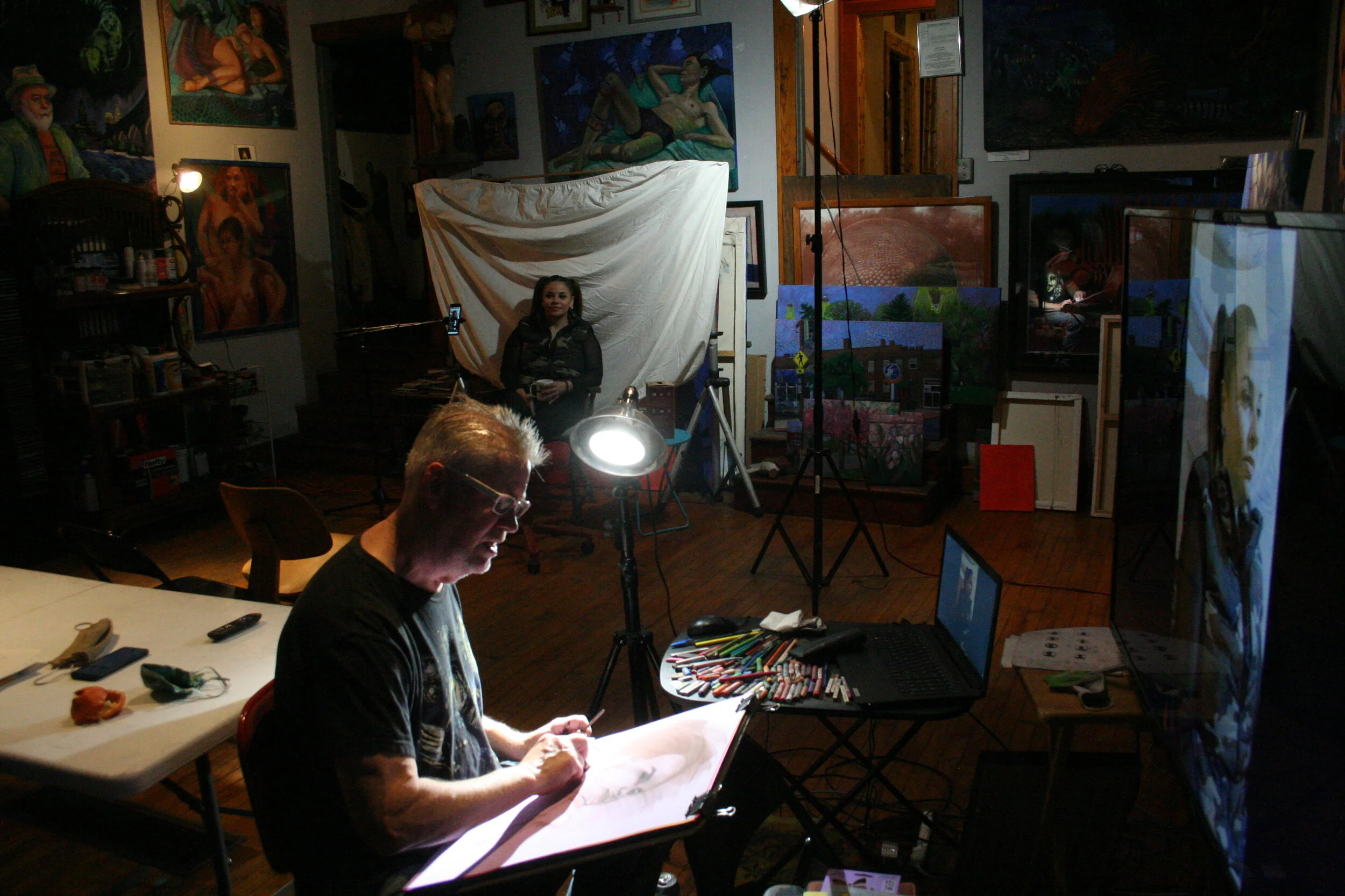 Laura posing while Timothy Herron draws from the monitor. Photo by Brian Pierce