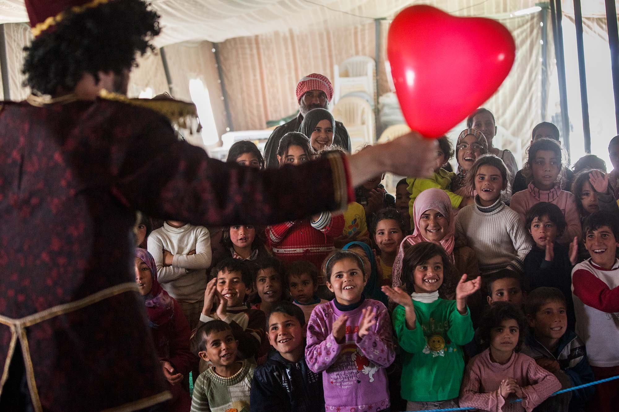  Momo the clown from Clowns Without Borders Ireland impresses Syrian children with his heart balloon trick at Zaatari refugee camp.&nbsp; 