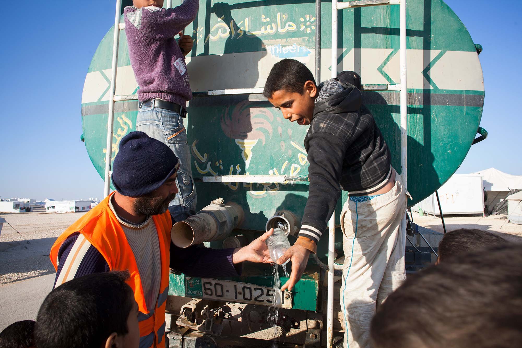  The water truck passes through district 4 of Zaatari refugee camp and the children scramble to make sure they get water for themselves and their families.  