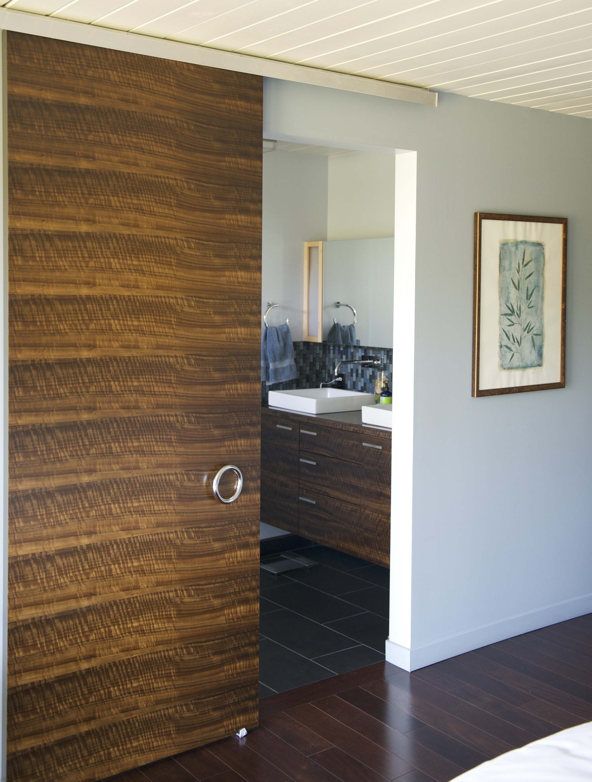 The master suite door, master bath door, and vanity are of fumed Eucalyptus. This is a process where the veneers are exposed to ammonia until they acquire the desired darkness. Too long exposure will turn them black. There is no dye or stain used in this process. 