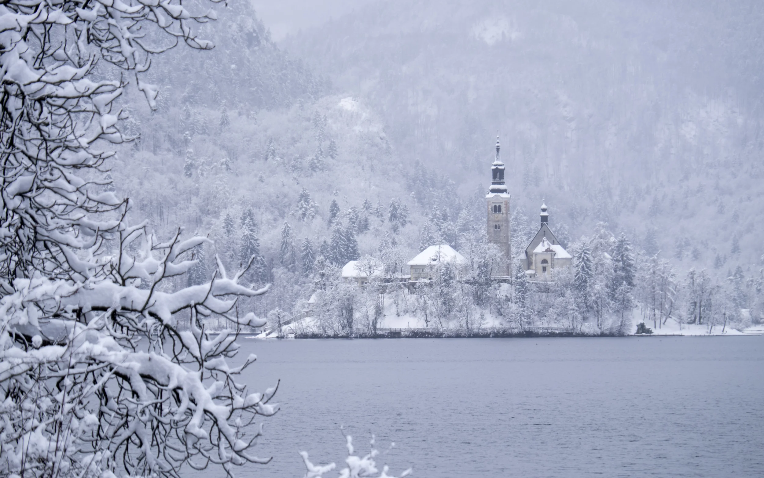  General view on Lake Bled in Slovenia with its Castle and church during a snow storm
 