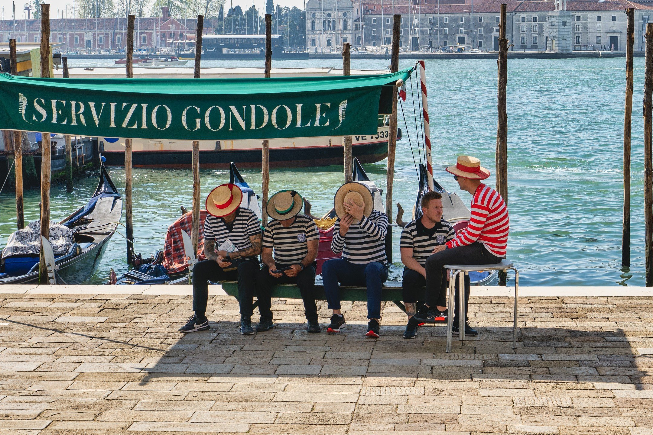 Paused moments in the city of canals. As the gondolas gently sway on the water, these icons @gondola_traghetto_danieli of Venice take a well-deserved break under the Mediterranean sun. 🛶✨ #VenetianVibes #GondolierLife #danieligondola #SerenityByTheS