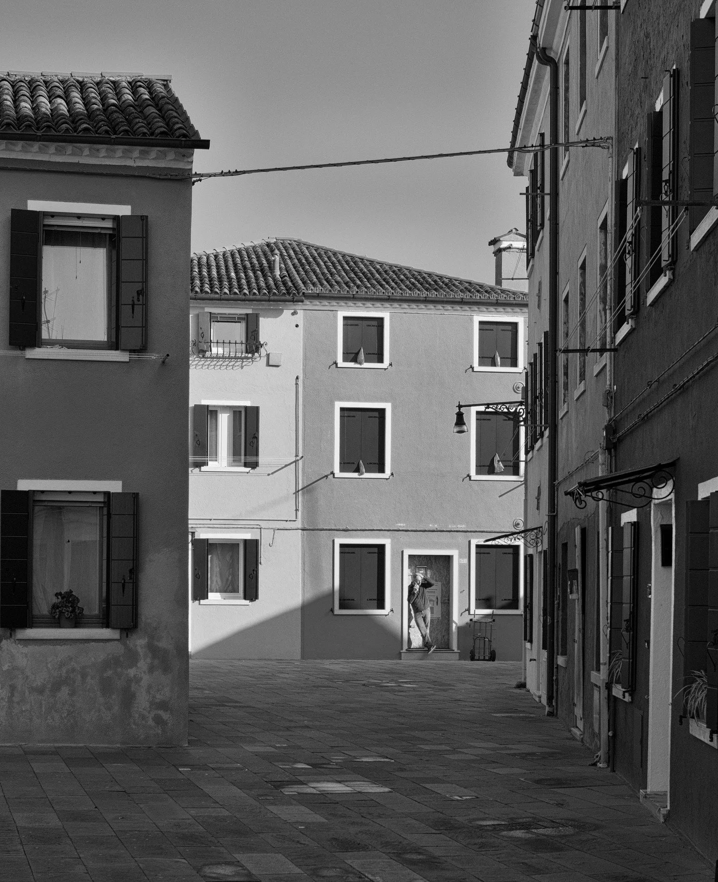 Alright, Burano behaving itself for once. Black and white, quiet geometry, shutters doing their thing, and one human exactly where you want them, not where they insist on being.

This is why I love small squares of light and patience more than loud c