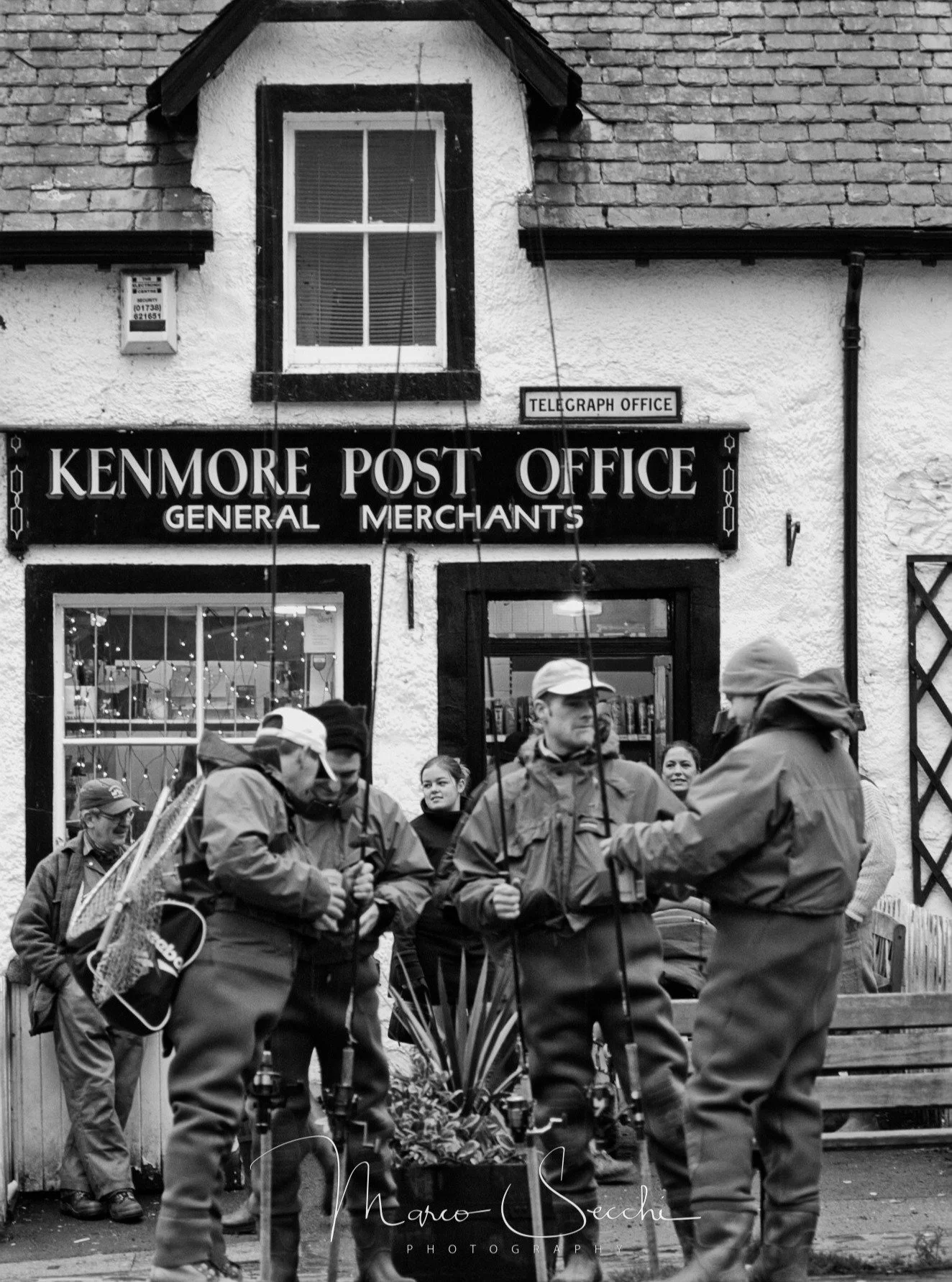 A few minutes before the ceremony marking the opening of the salmon fishing season in Kenmore, Scotland, sometime before 2000.

The fishermen gather outside the old Post Office with rods, waders and landing nets ready. I like these moments just befor