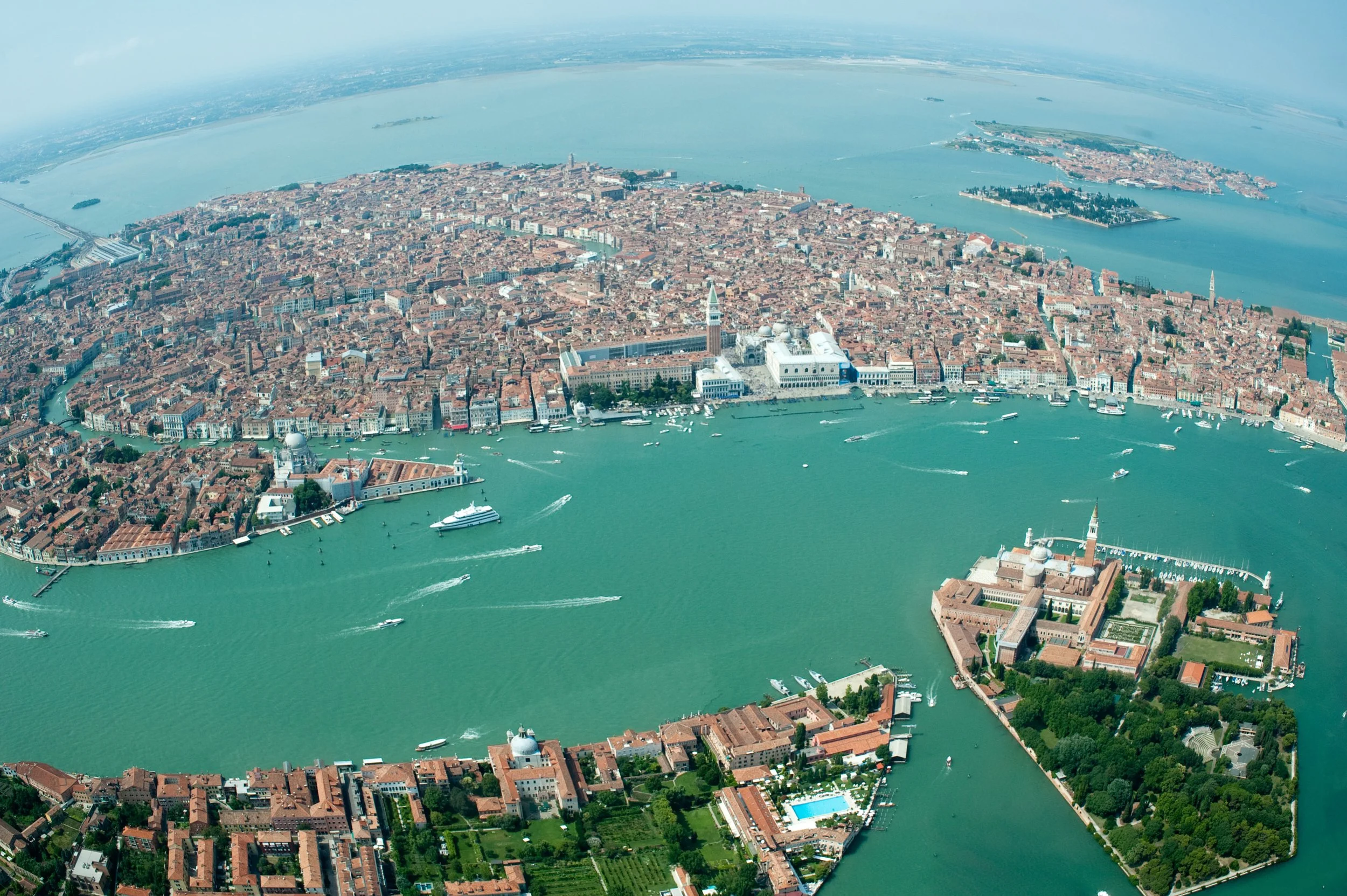 Venice from a seaplane becomes a different city.

At street level, we experience it in fragments: a narrow passage, a bridge, a sudden opening onto the water. From above, those fragments become a structure. San Marco, San Giorgio Maggiore, the lagoon