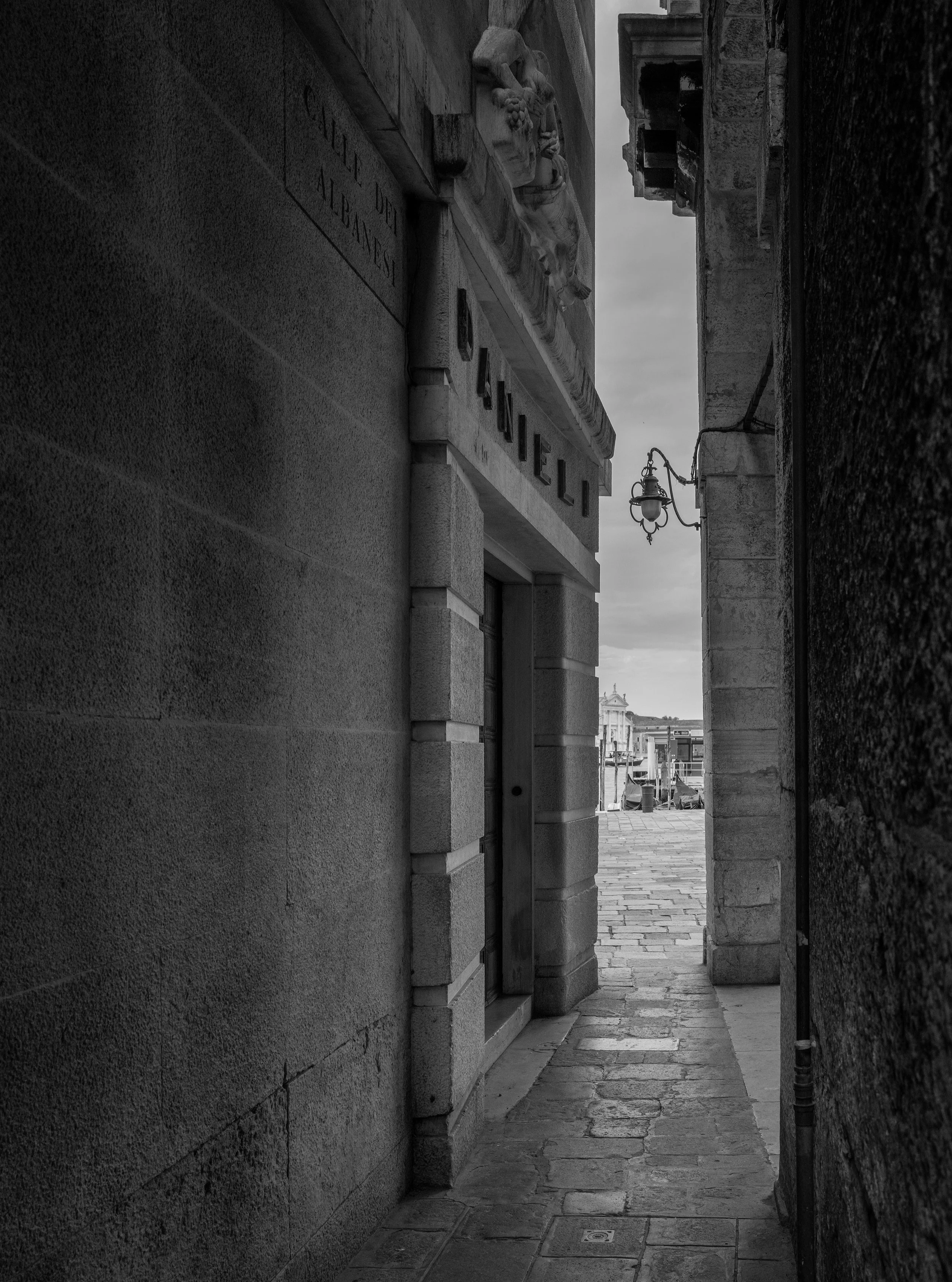 Calle dei Albanesi, Venice.

Everyone knows the front of the Danieli. The Riva, the lobby, the lagoon view with a price tag. This is the other side. A narrow calle, a stone wall, a single lamp, and the name cut into the lintel.

The calle does what V