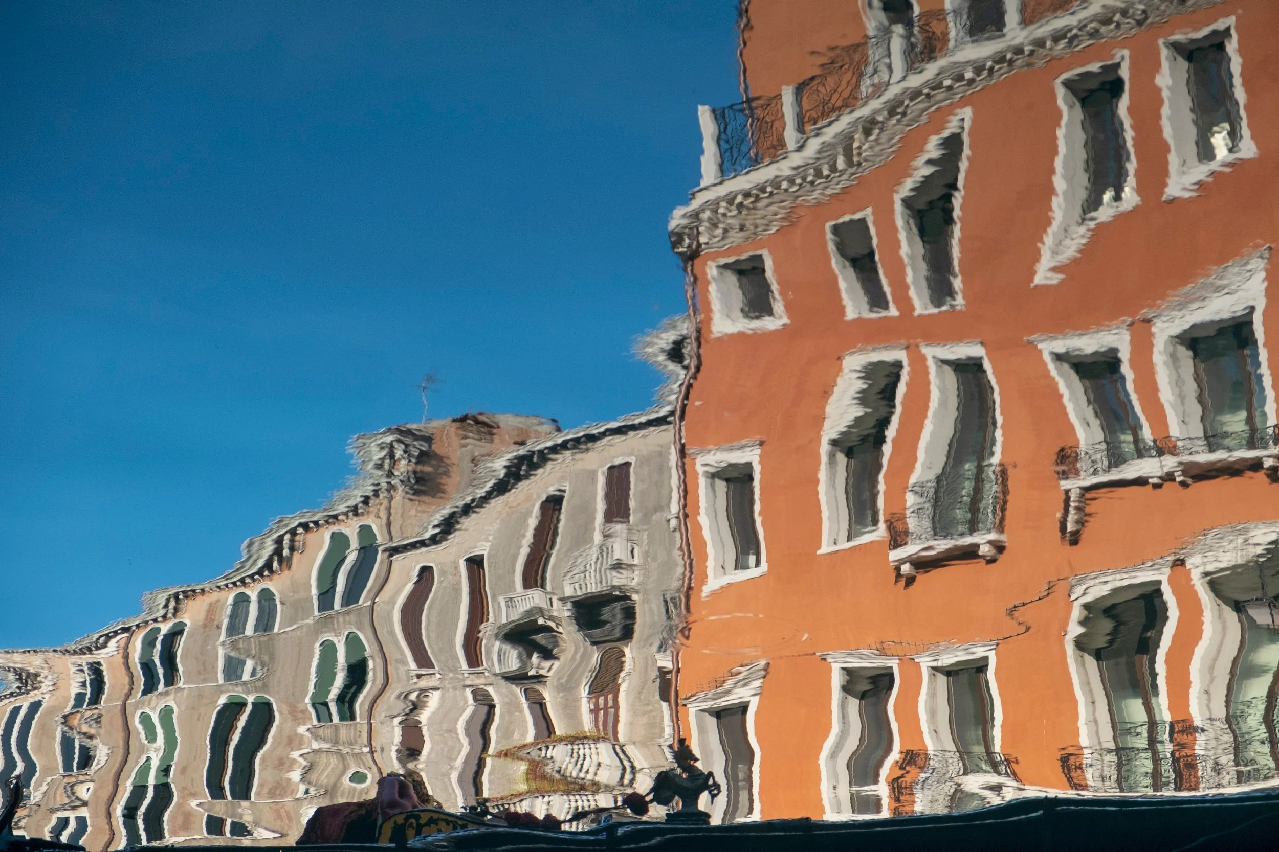 The windows are still recognisable, but their straight lines have become wonderfully unreliable. Reflected in the canal, the fa&ccedil;ades stretch and bend, with the orange wall holding the composition together.

This is something I enjoy about phot