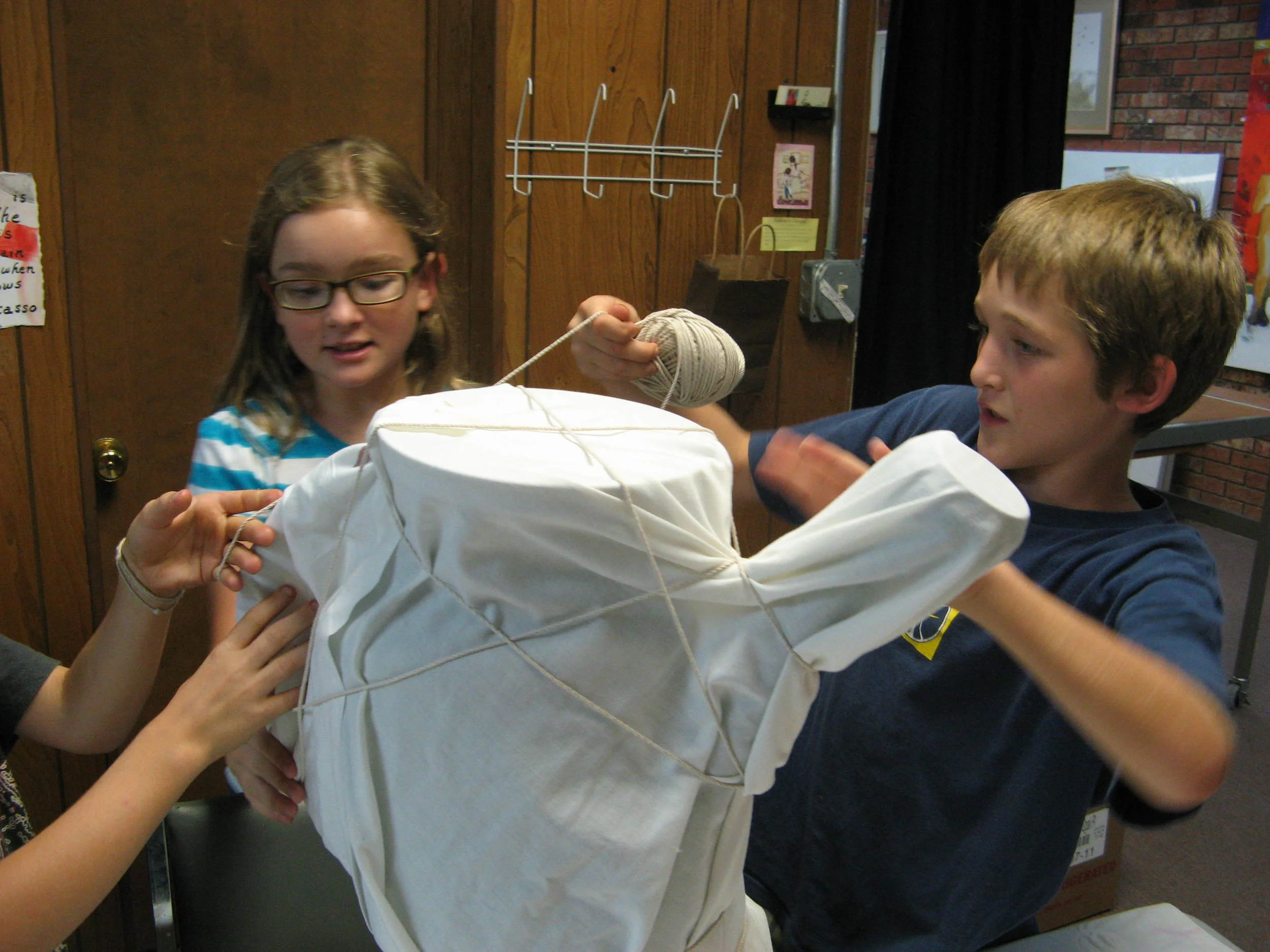 Students wrap an object in Christo art history lesson.
