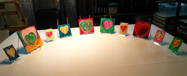 A selection of Anam Cara desk icons and pocket paintings by Catherine Jo Morgan, laid in a "painting circle" at the studio cabin