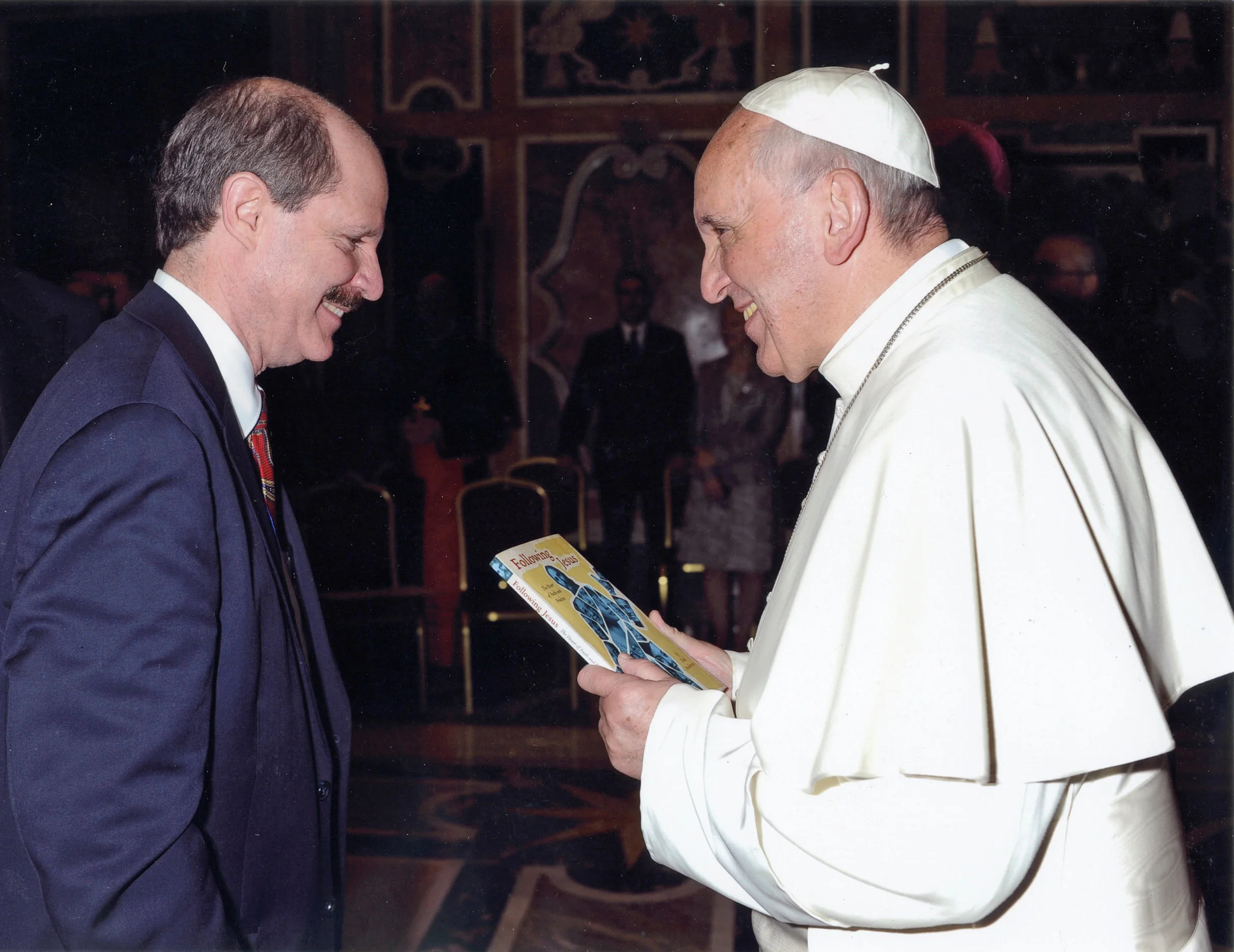 Paul gives a copy of his book, Following Jesus , to Pope Francis.