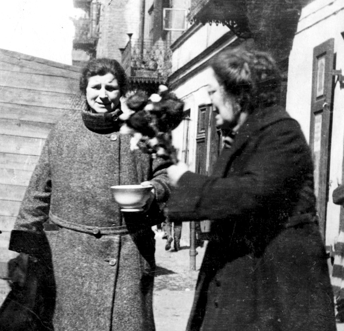 Two neighbors interacting at the community farmer's market courtesy of the Jewish Historical Institute, photograph by Menakhem Kipnis - http://www.jhi.pl