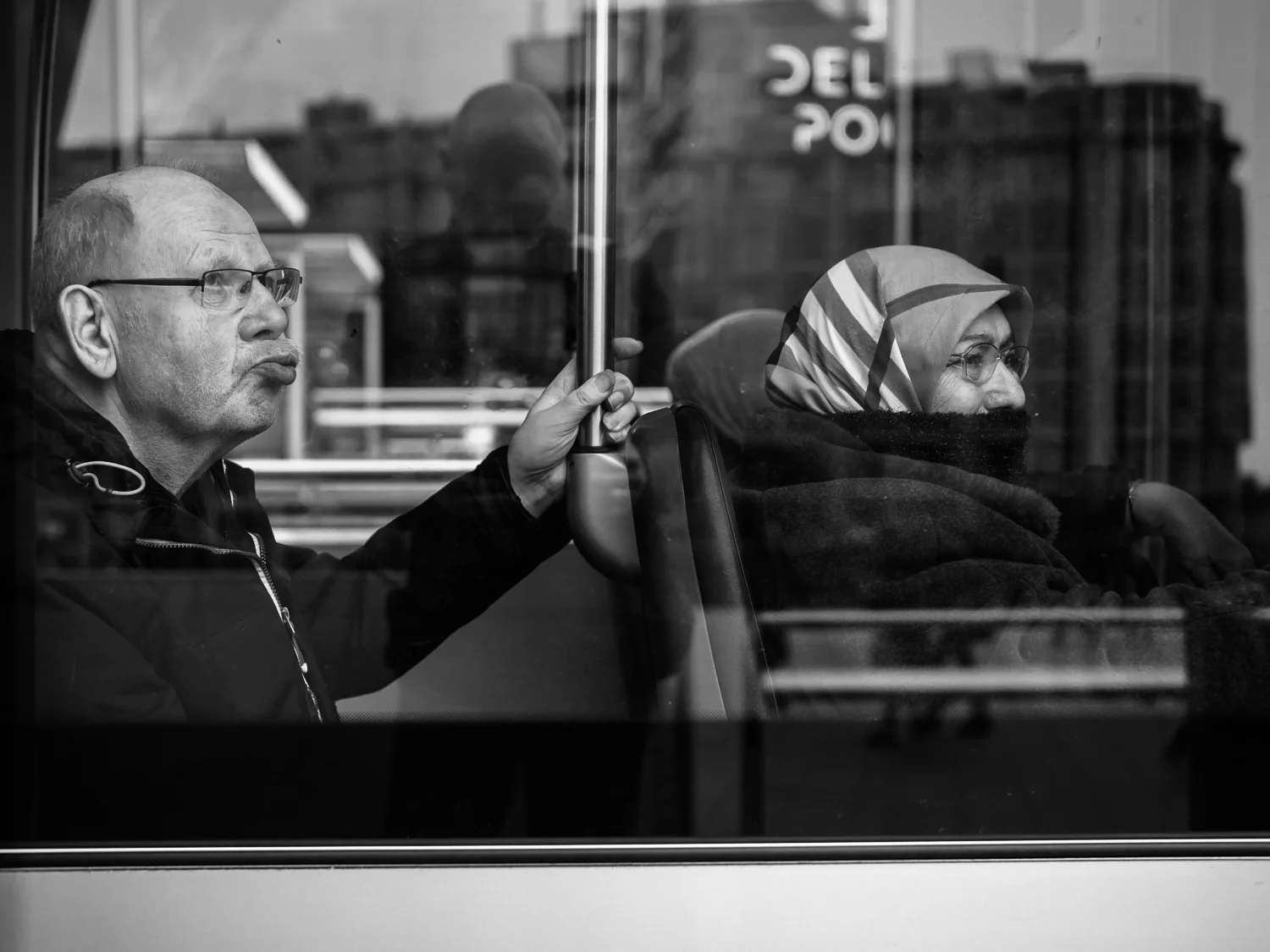 Shot taken during my workshop street photography in Rotterdam. Endless possibilities to make photos of people behind glass in trams, trains, buses and restaurants. Be aware of your own reflection when you shoot at 90 degrees. It's safer to choose a slightly different angle, preferable to show the face of your main character. Shot with Olympus OMD1 Mark 2 and Olympus 25mm f/1.2