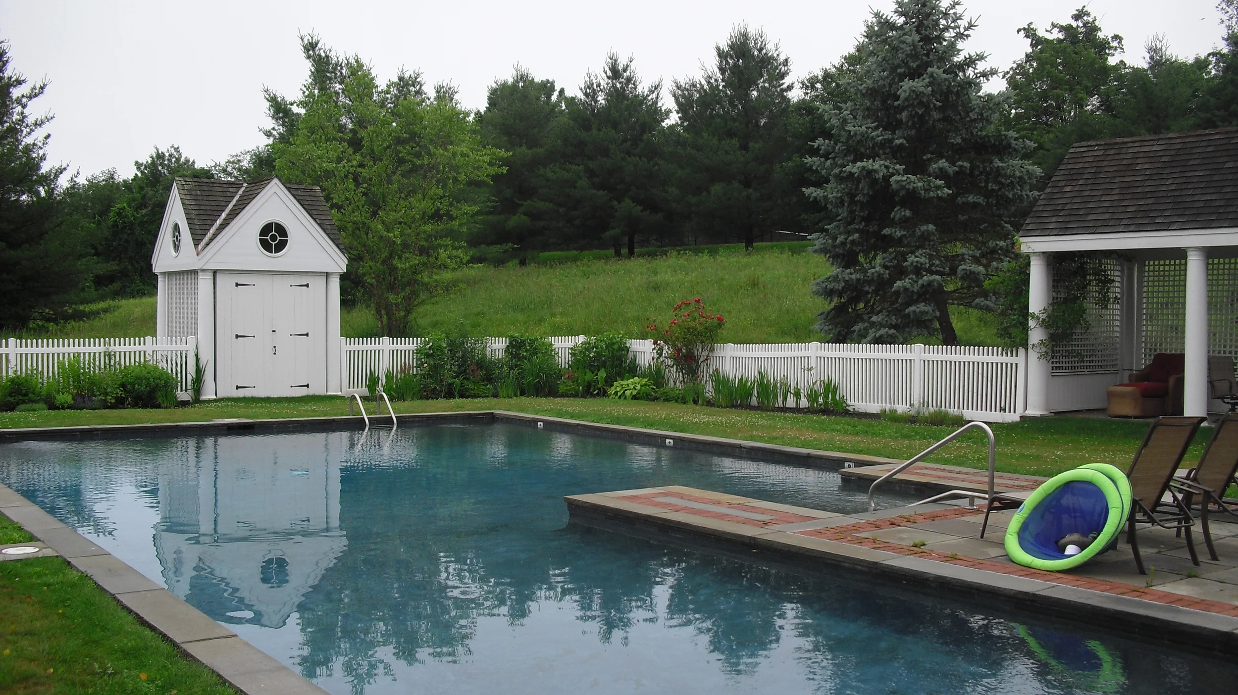 Before photo showing old fence and equipment shed